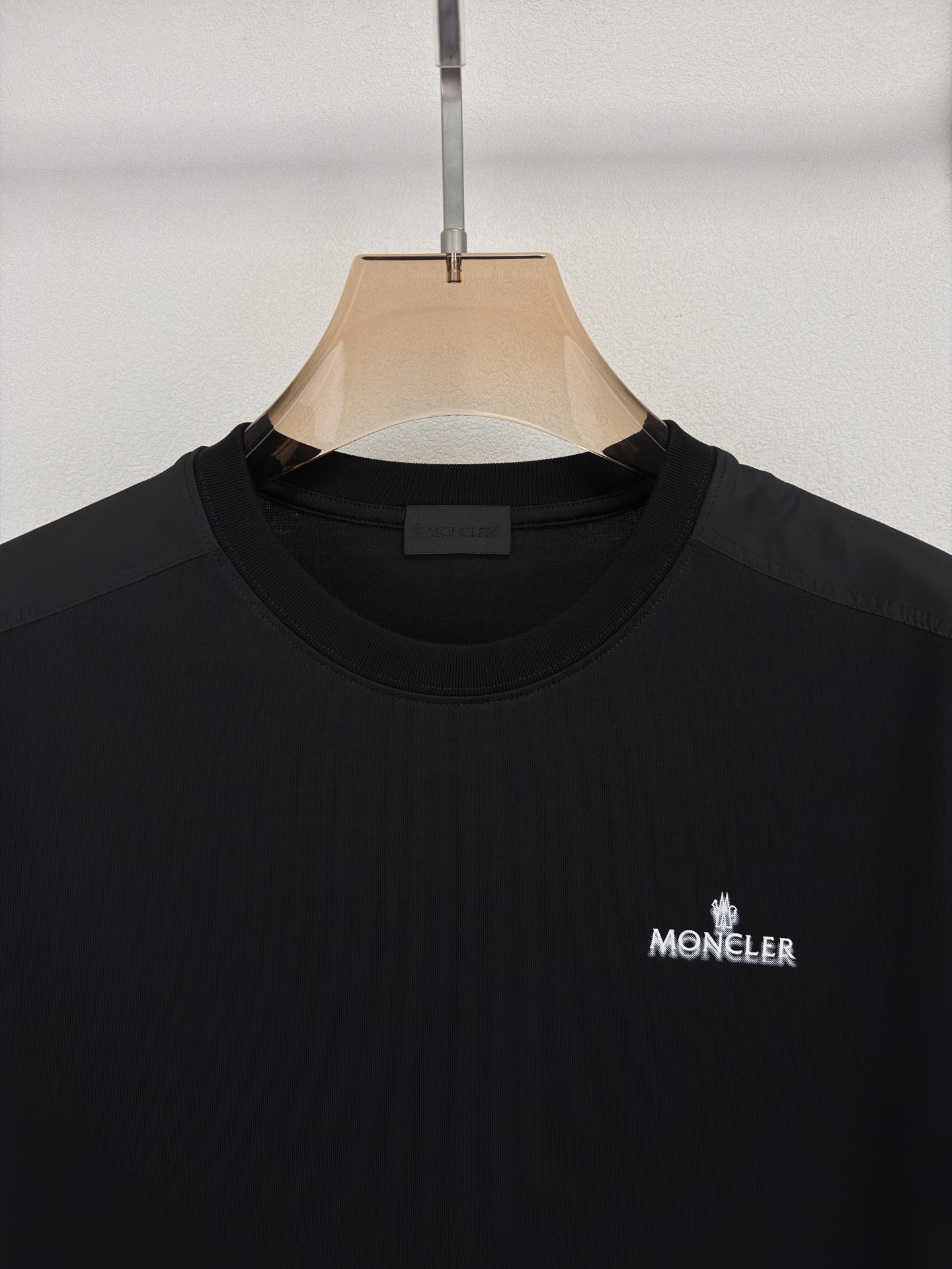 MONCLER 26春夏 黑标系列，这款T恤是品牌DNA的现代创新宣言——将经典的户外黑标系列标志大胆重