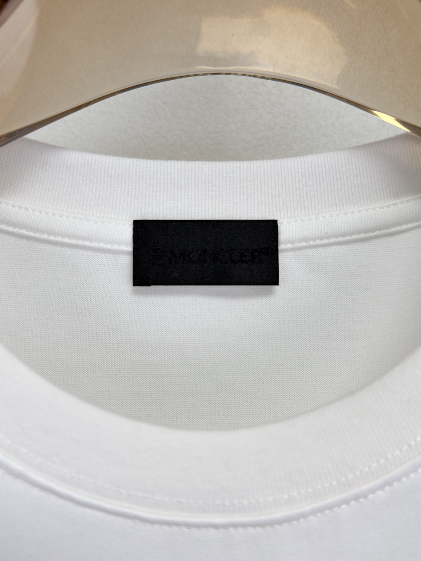 MONCLER 26春夏 黑标系列，这款T恤是品牌DNA的现代创新宣言——将经典的户外黑标系列标志大胆重