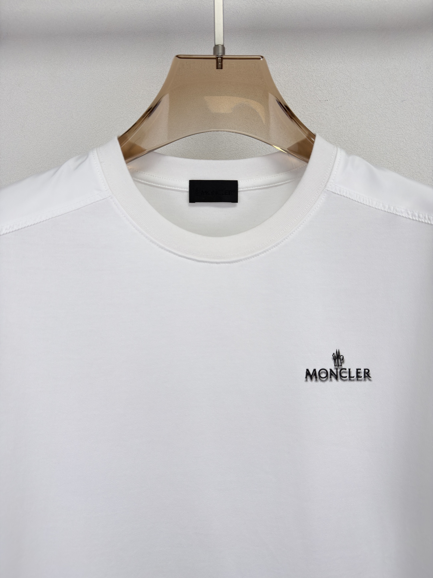 MONCLER 26春夏 黑标系列，这款T恤是品牌DNA的现代创新宣言——将经典的户外黑标系列标志大胆重