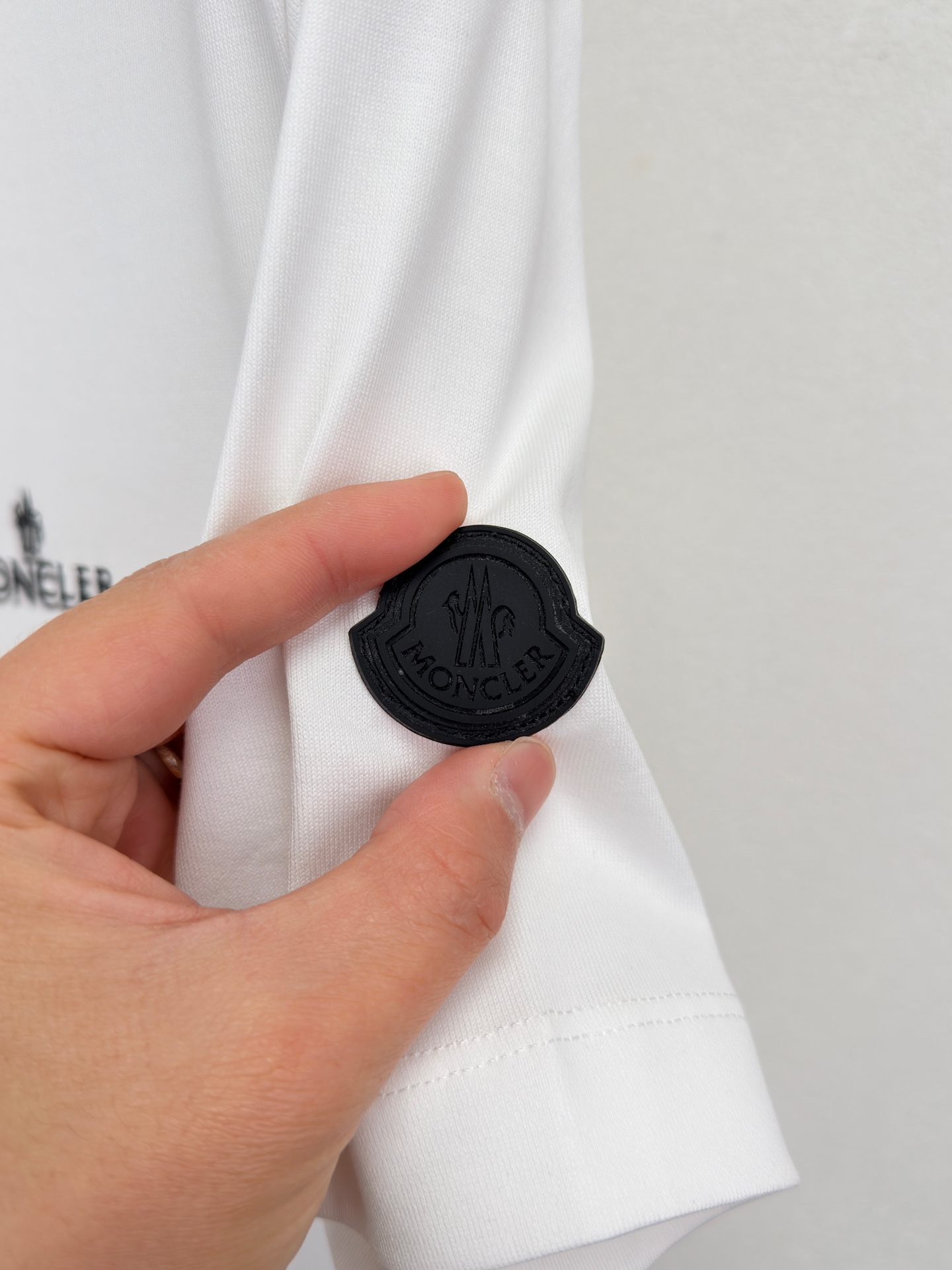 MONCLER 26春夏 黑标系列，这款T恤是品牌DNA的现代创新宣言——将经典的户外黑标系列标志大胆重