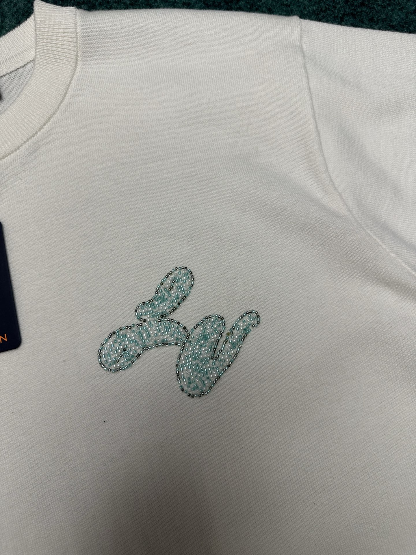 
驴家     25ss新款短袖圆领衫取材素净棉布，以下摆珠饰 Damier 格纹刺绣致意莹泽泳池瓷砖，
