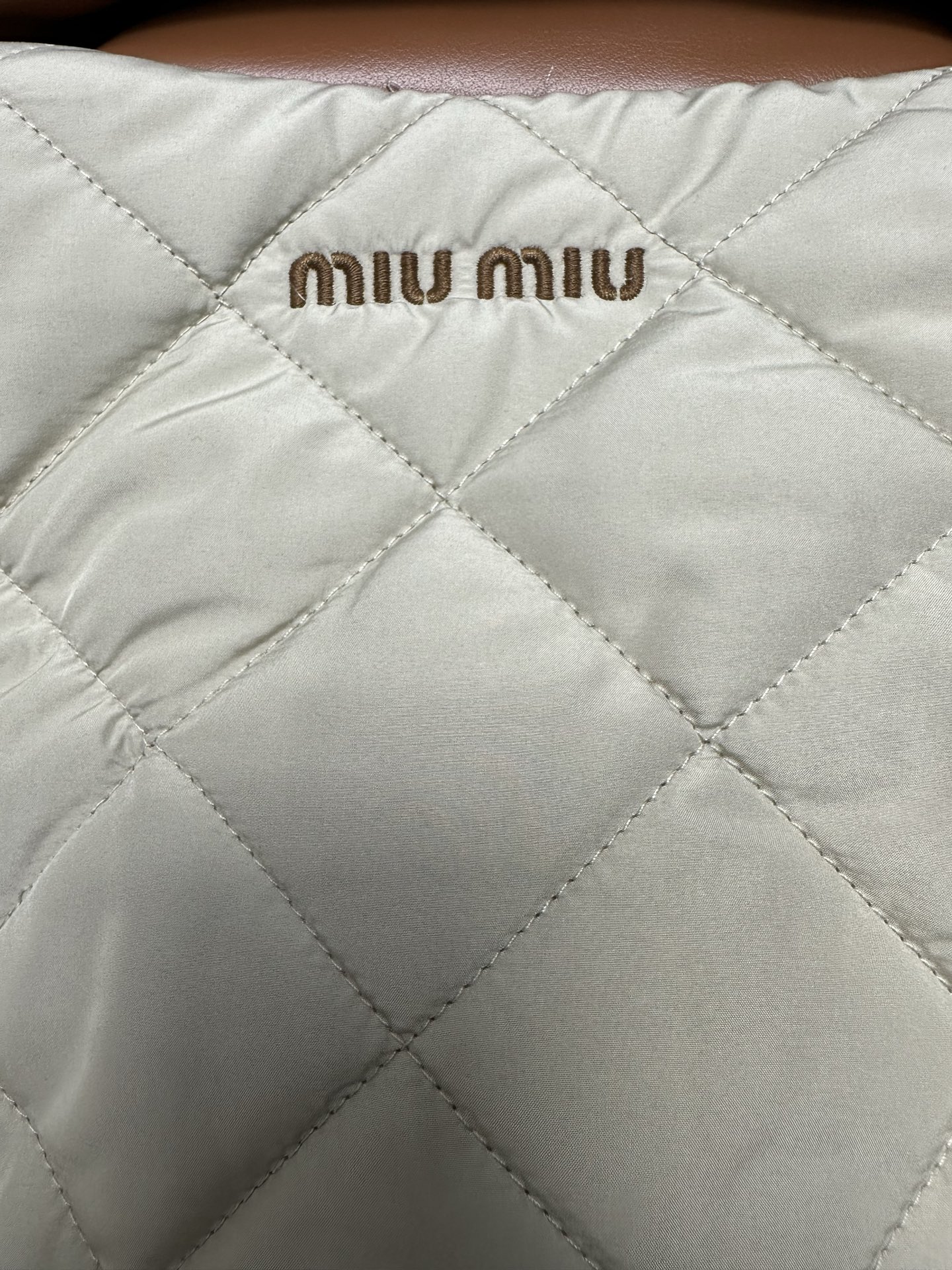 MIUMIU 25ss新款夹克重新诠释经典绗缝羽绒服，以轻盈的重量和柔软的宽松版型脱颖而出，与低调的绒面