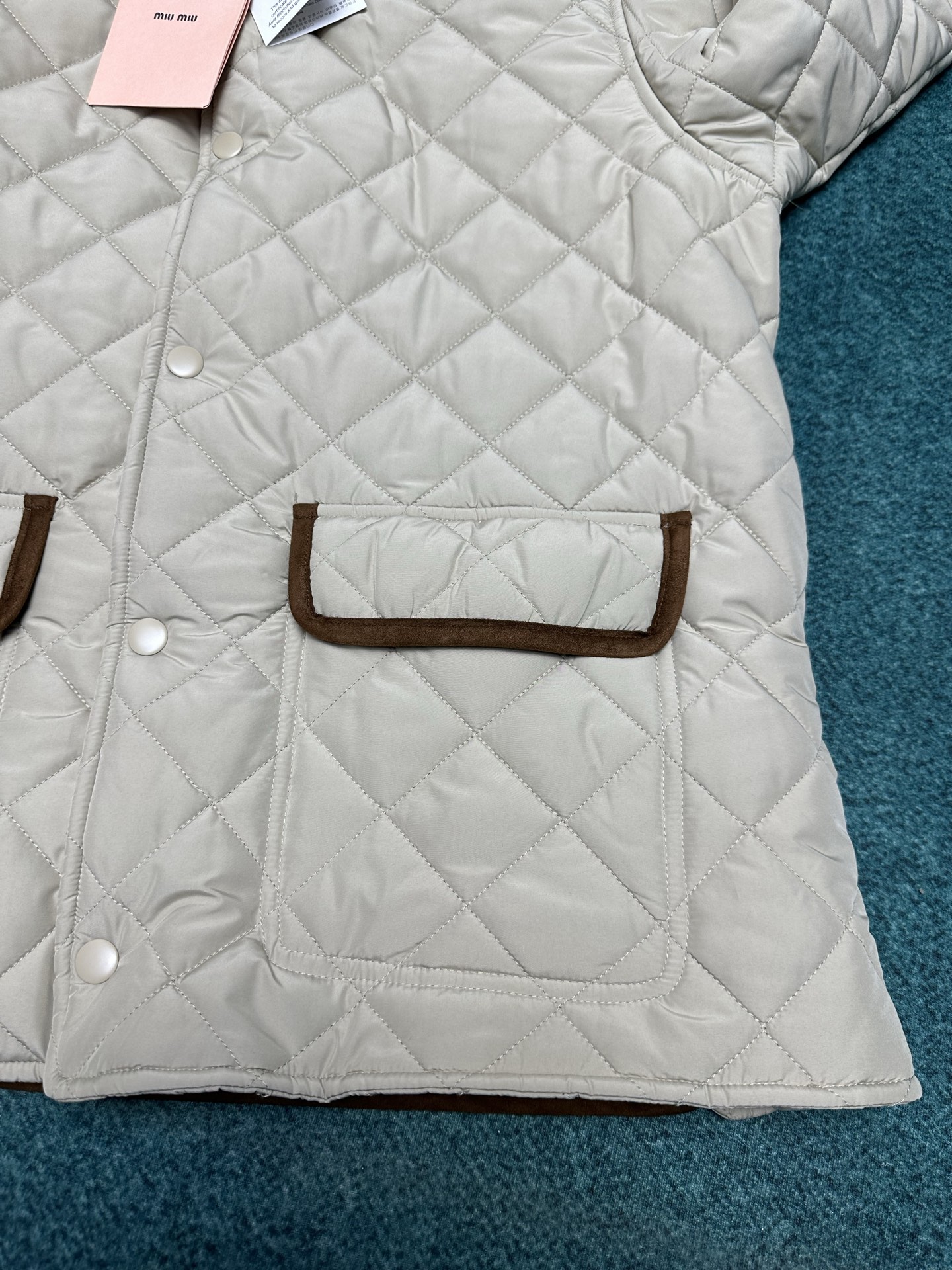 MIUMIU 25ss新款夹克重新诠释经典绗缝羽绒服，以轻盈的重量和柔软的宽松版型脱颖而出，与低调的绒面