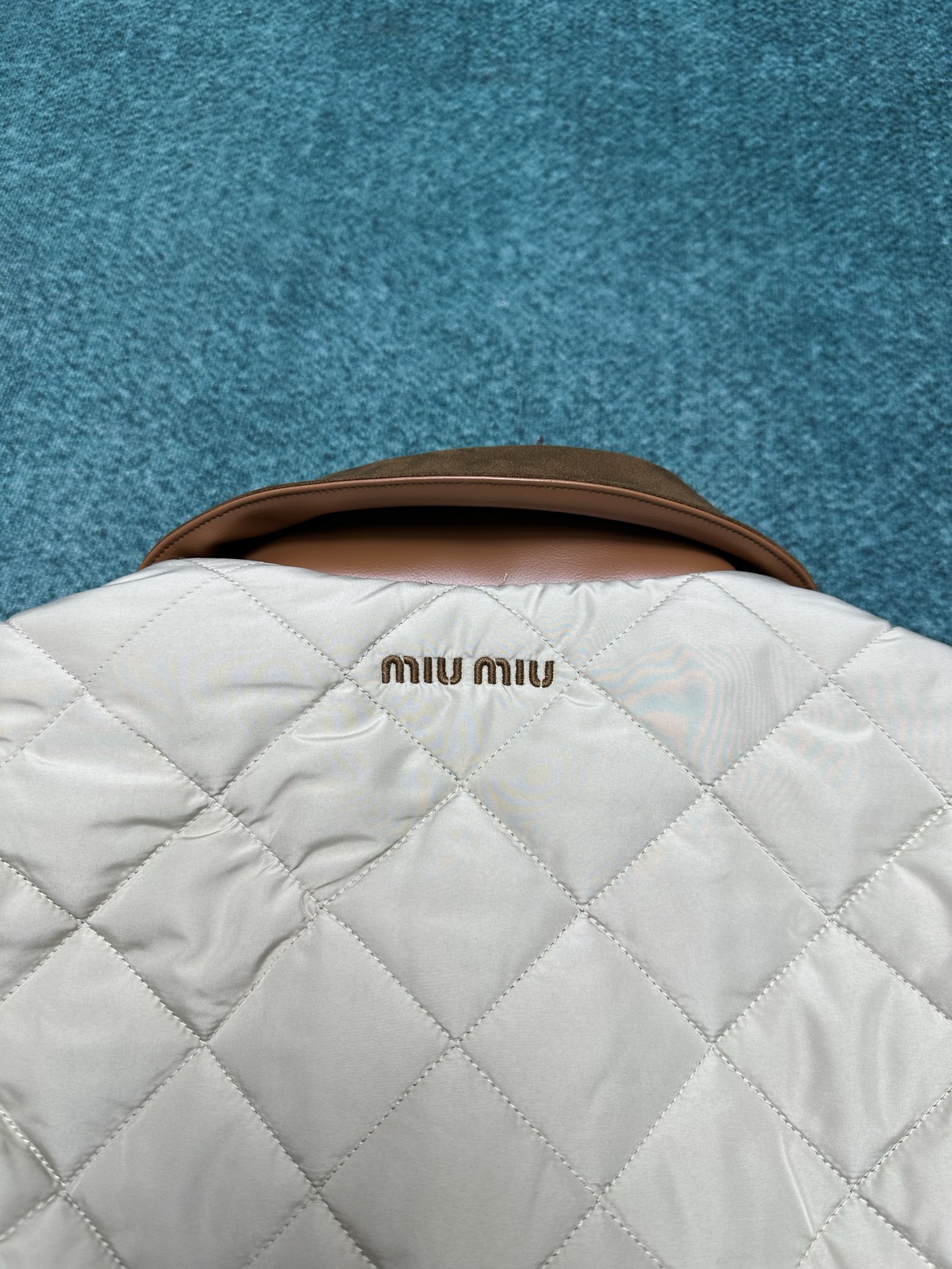 MIUMIU 25ss新款夹克重新诠释经典绗缝羽绒服，以轻盈的重量和柔软的宽松版型脱颖而出，与低调的绒面