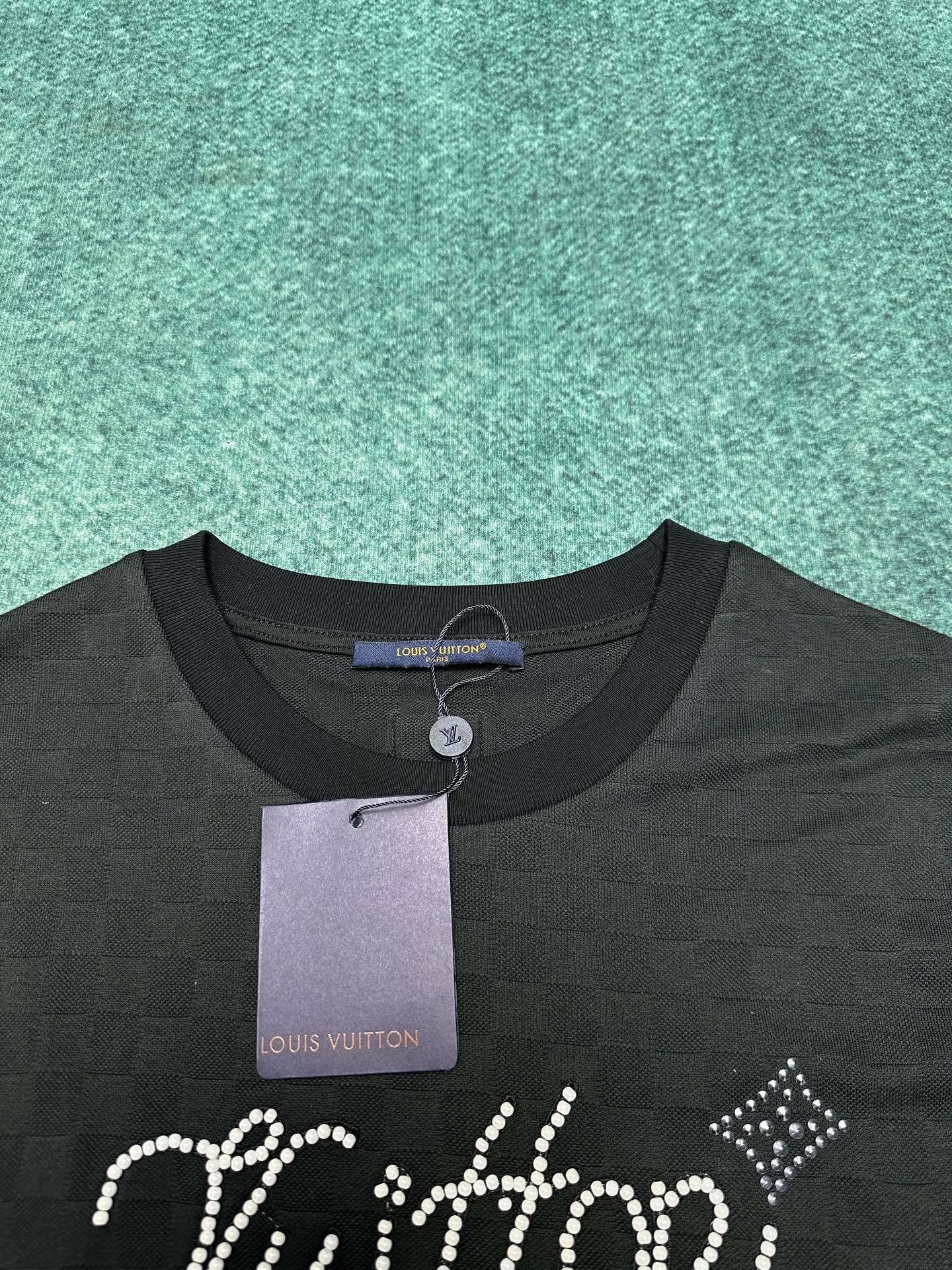 驴家 25ss新款珠地棉 T 恤以 Damier 提花呈现细腻肌理，再以莹亮串珠于胸前勾勒手写体 Vui