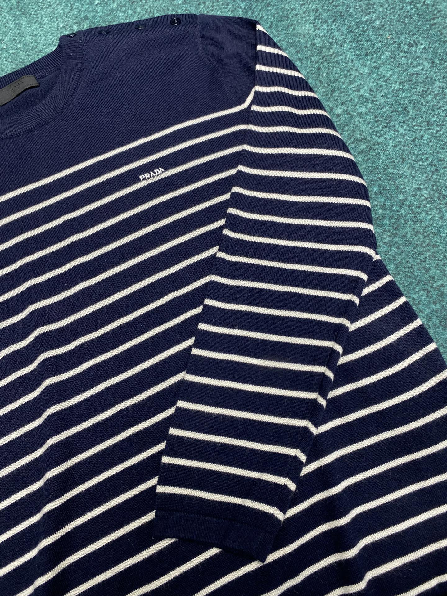 普拉达 25ss新款条纹羊毛圆领毛衣修长线条，严谨平衡。三粒钮扣侧开合以意想不到的方式打破对称。码数：S