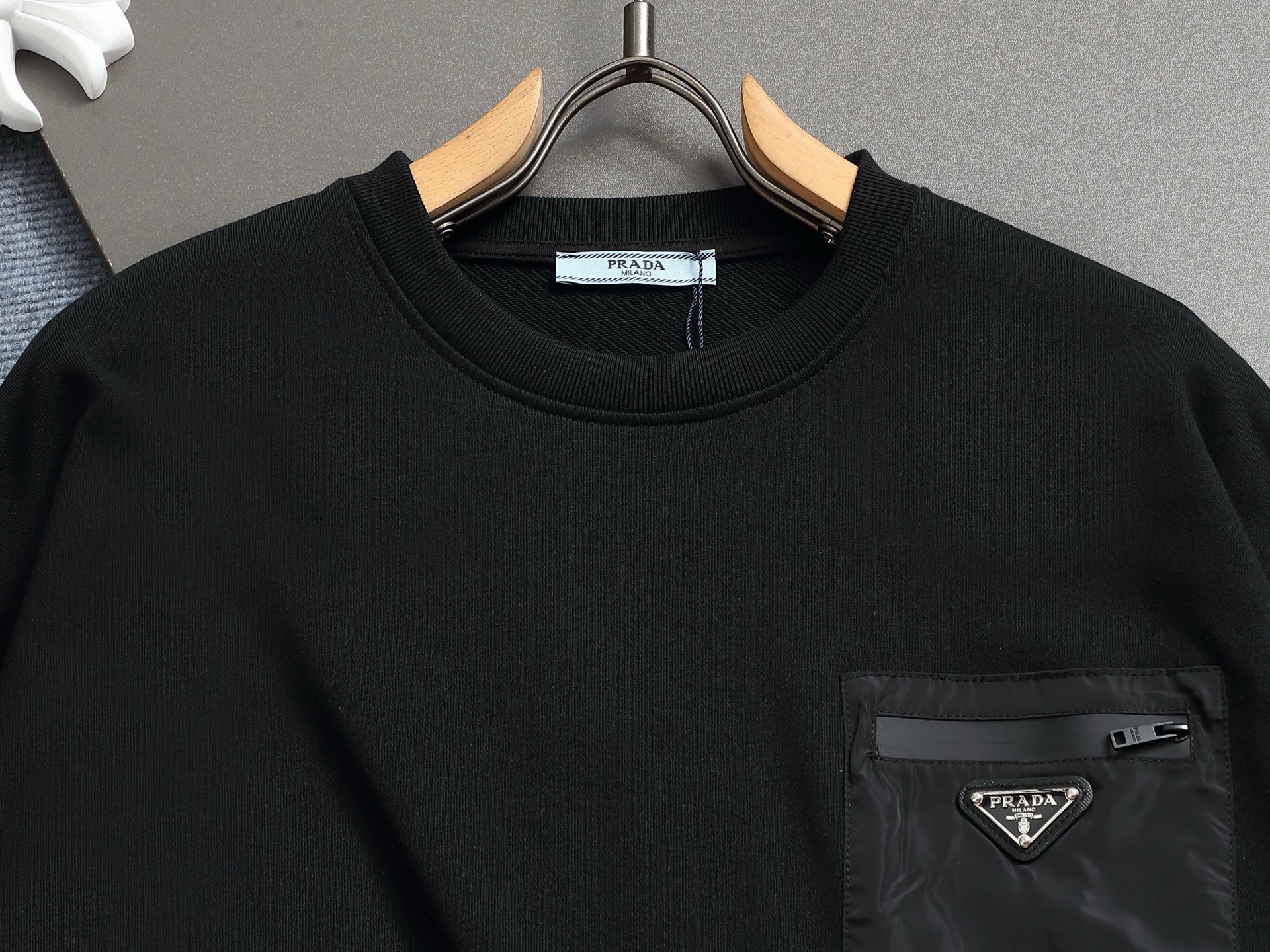        PRAD*微宽版型
普拉达/25ss新款胸前三角标口袋款圆领卫衣，这款卫衣融运动风极简主义