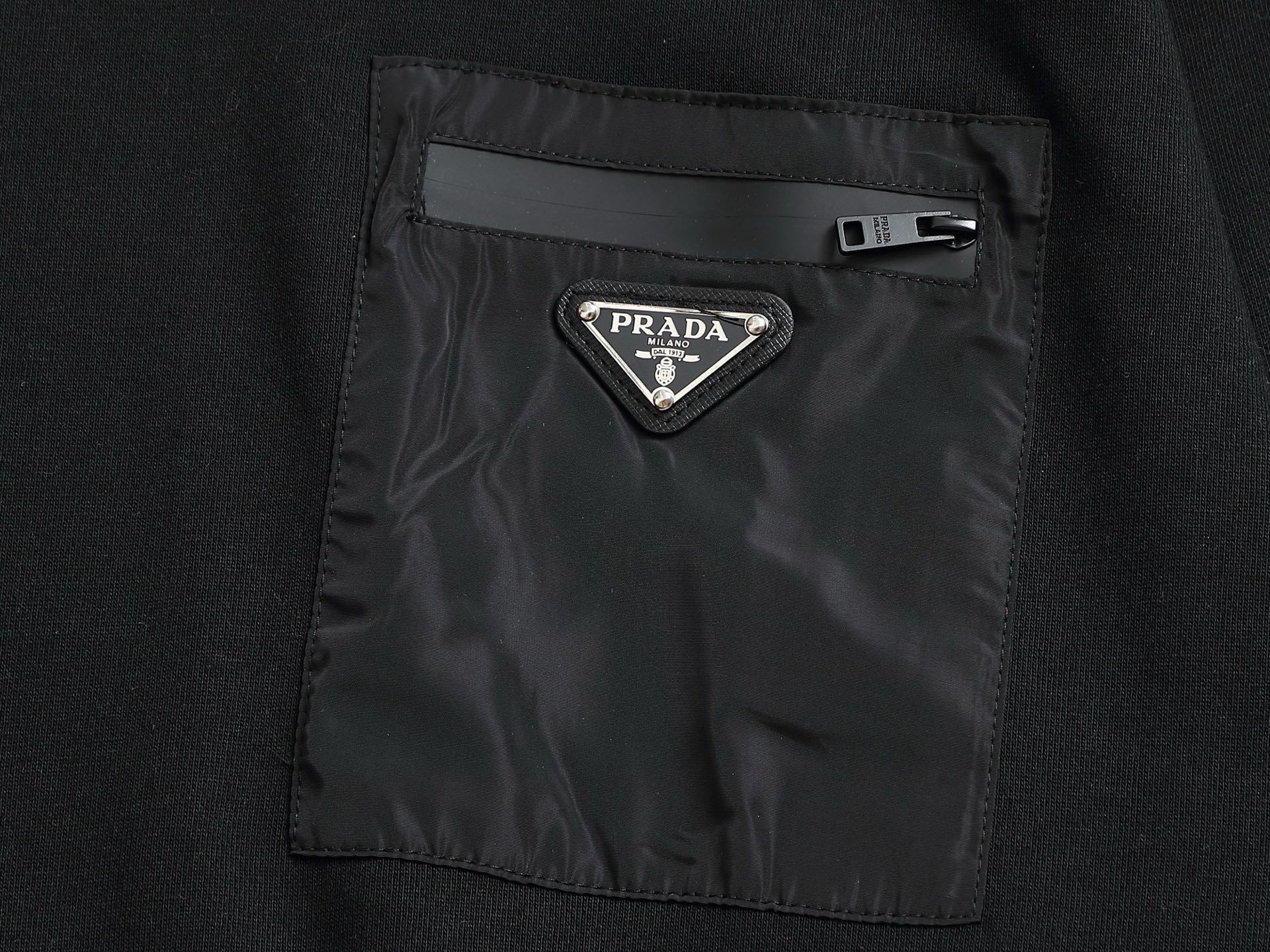        PRAD*微宽版型
普拉达/25ss新款胸前三角标口袋款圆领卫衣，这款卫衣融运动风极简主义