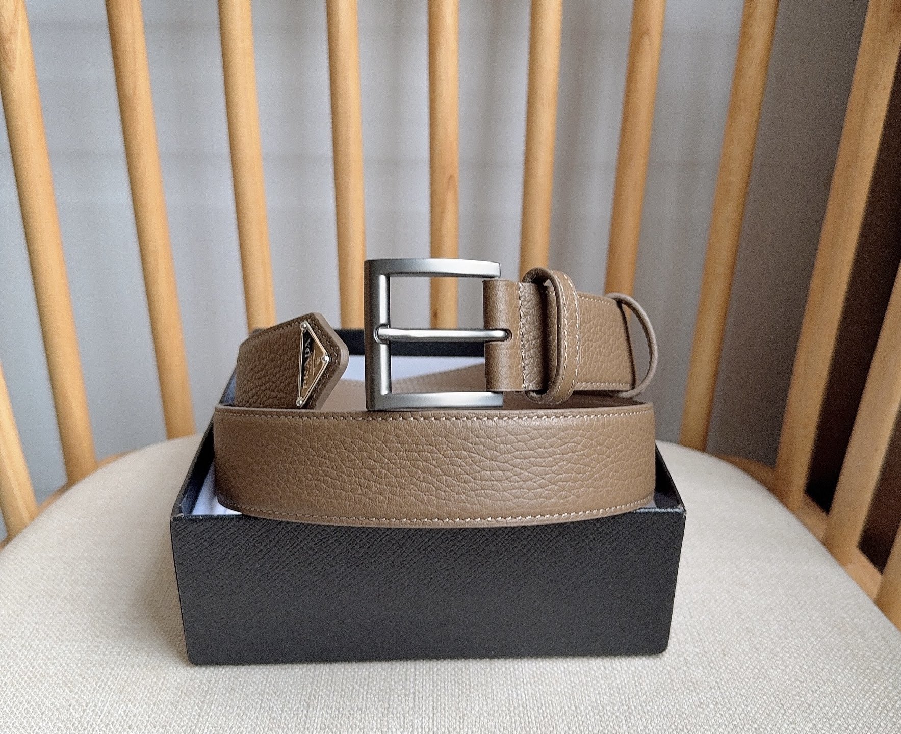 PRADA (普拉达) 专柜最新款 这款皮革腰带的尖部饰以标志性的涂珐琅金属三角形徽标 此徽标由Mari