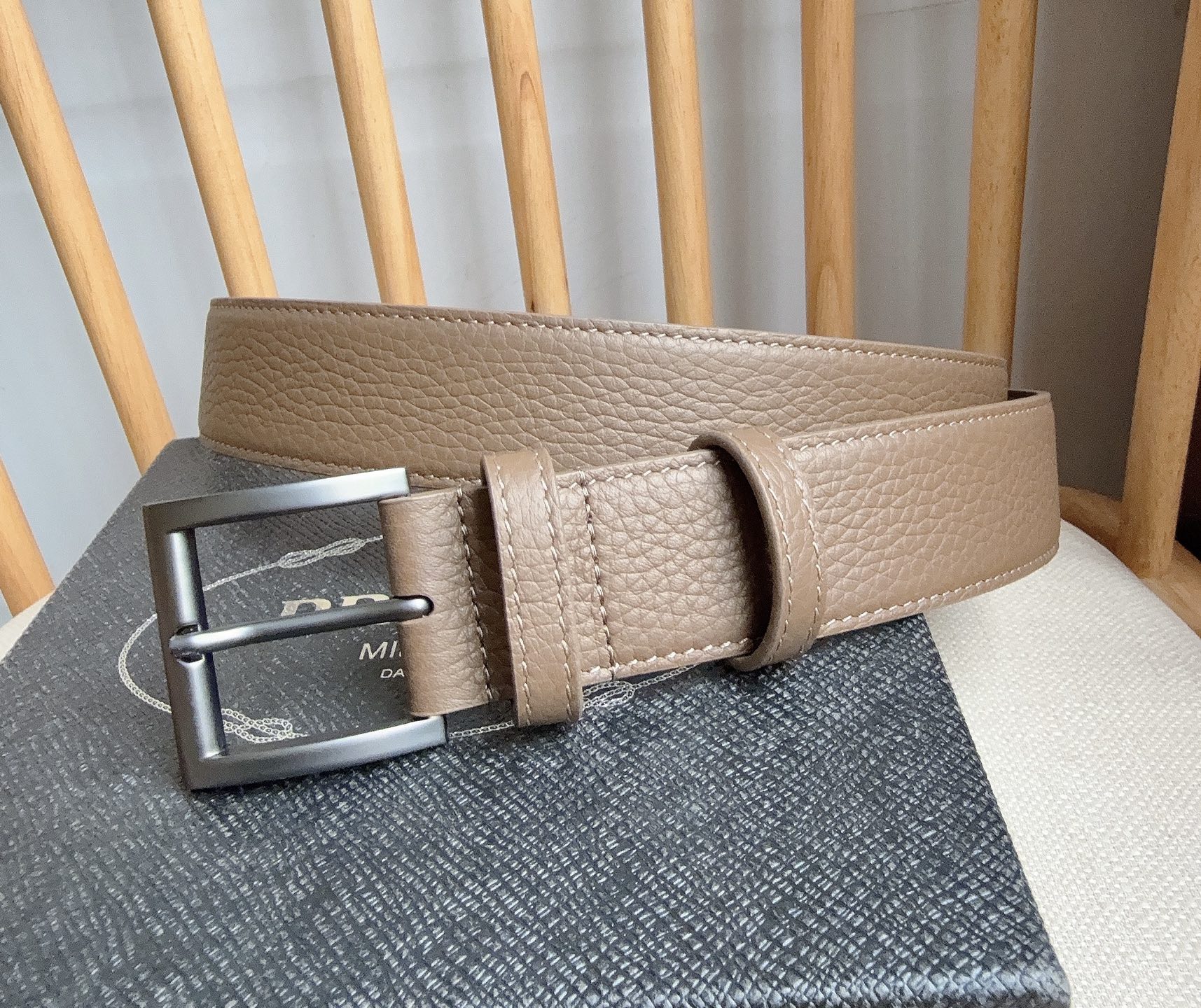 PRADA (普拉达) 专柜最新款 这款皮革腰带的尖部饰以标志性的涂珐琅金属三角形徽标 此徽标由Mari