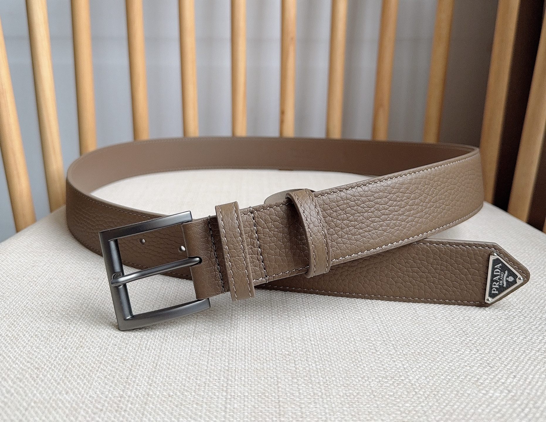 PRADA (普拉达) 专柜最新款 这款皮革腰带的尖部饰以标志性的涂珐琅金属三角形徽标 此徽标由Mari