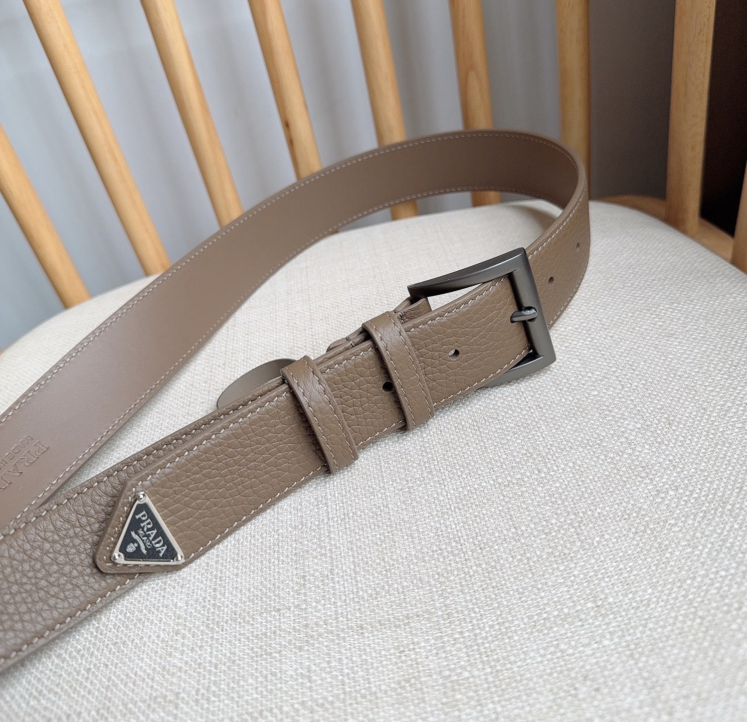 PRADA (普拉达) 专柜最新款 这款皮革腰带的尖部饰以标志性的涂珐琅金属三角形徽标 此徽标由Mari