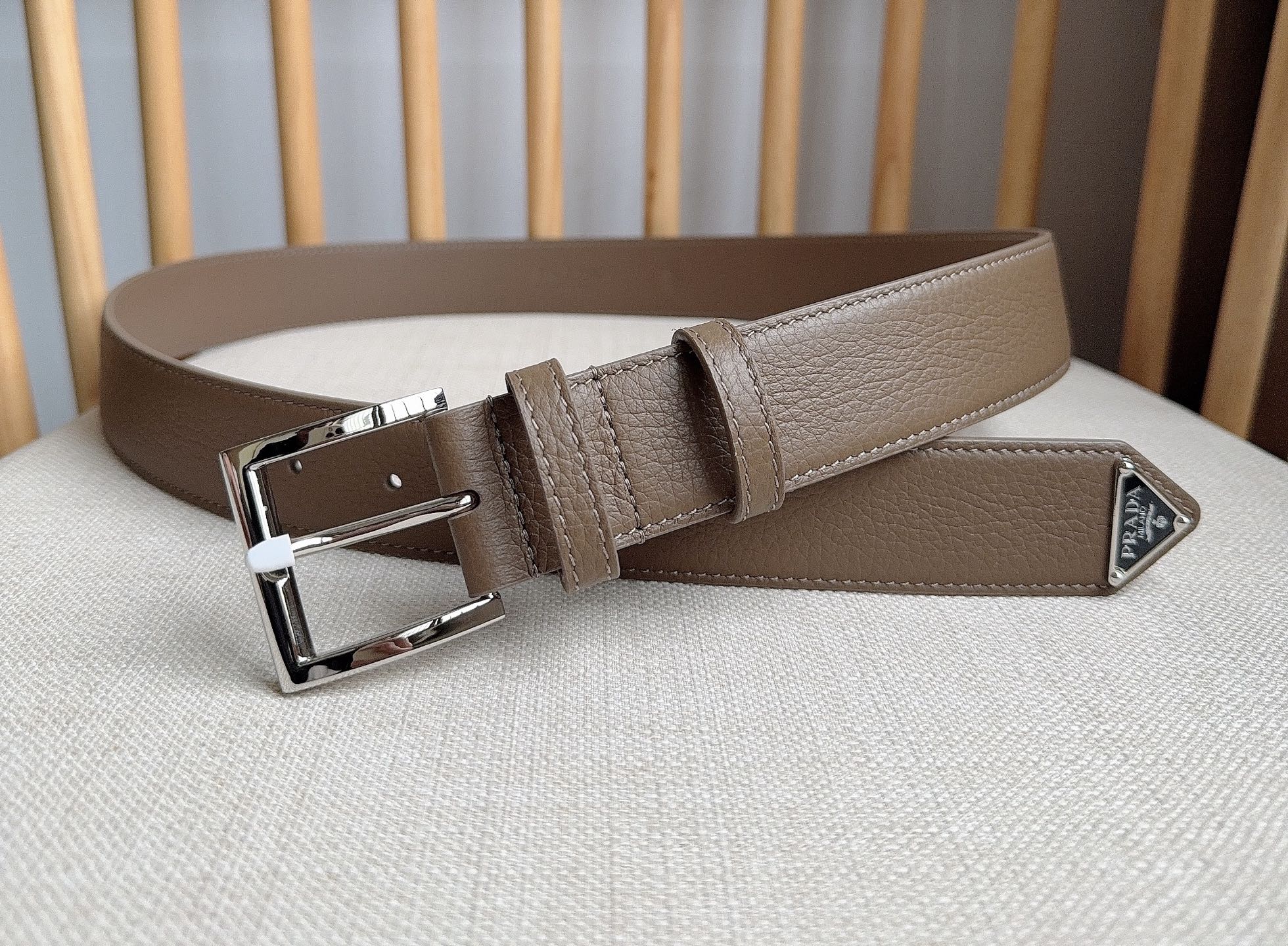 PRADA (普拉达) 专柜最新款 这款皮革腰带的尖部饰以标志性的涂珐琅金属三角形徽标 此徽标由Mari