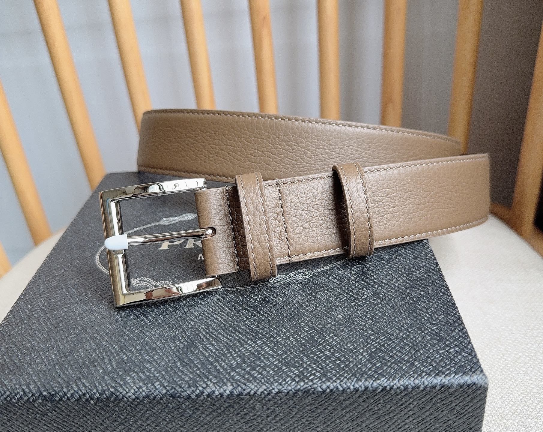 PRADA (普拉达) 专柜最新款 这款皮革腰带的尖部饰以标志性的涂珐琅金属三角形徽标 此徽标由Mari