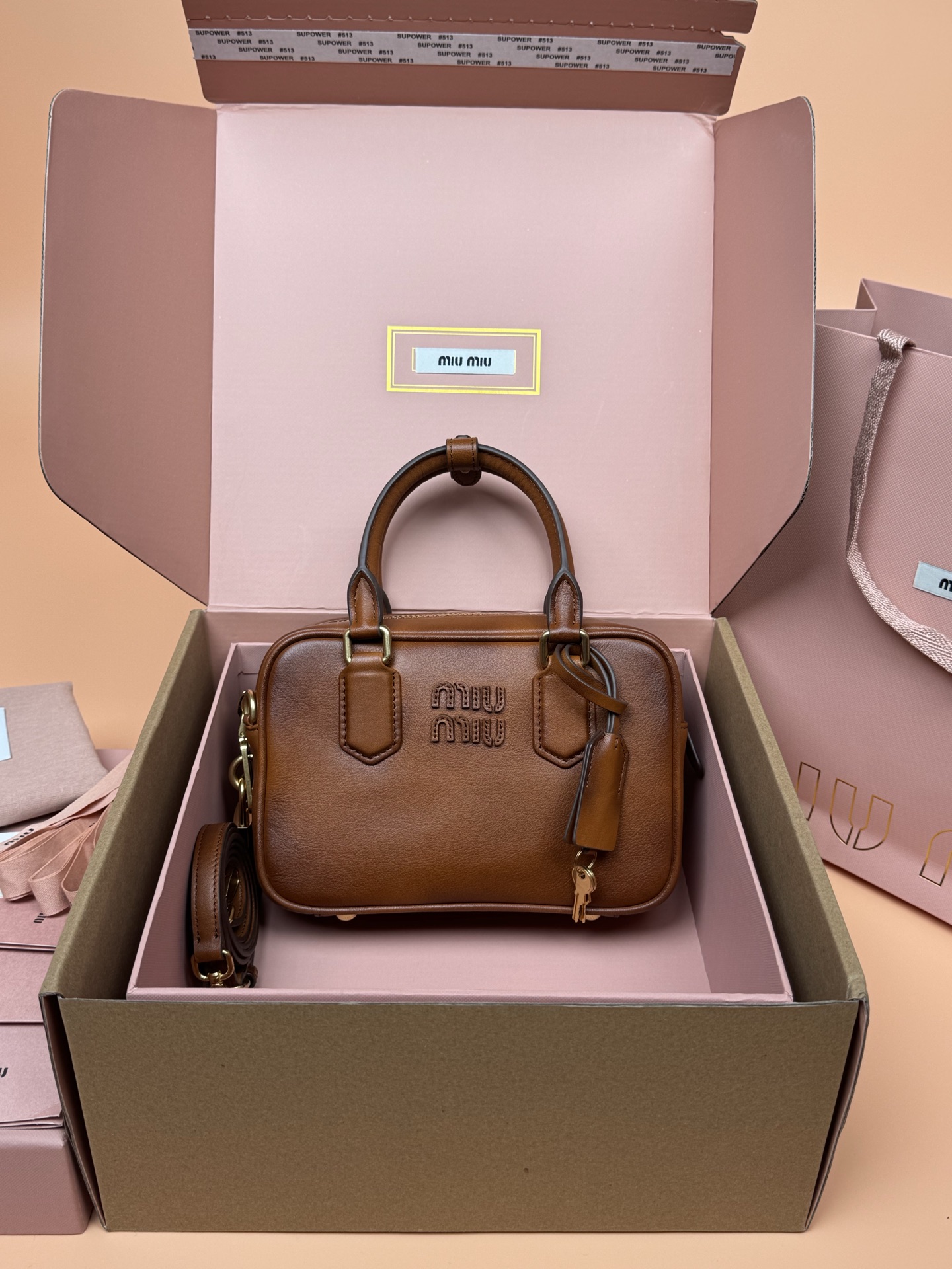 NO:583770,Original leather, with picture packaging [Premium Hardware Original Leather] Arcadie cow leather small (19cm) bowling handbag/crossbody bag ~ Retro Brown This handbag uses the retro exquisite texture of cowhide to bring a new interpretation to the classic silhouette. The letter logo on the front and the metal hardware cleverly echo, and the exquisite workmanship is outstanding, highlighting the highly recognizable classic style. Dynamic and elegant lines with adjustable and detachable shoulder straps, presenting a practical and versatile design with modern charm. ～Detachable and adjustable shoulder strap ～Zipper closure ～Lined, with 2 patch pockets ～With foot studs Size: W19×H13×D6cm No._5BB123, premium Miu Miu, satchels, crossbody bags, cowhide19860909原厂皮,配图片包装【特级五金原厂皮】Arcadie 牛皮革小号(19cm)保龄球手提包/斜挎包～复古棕 这款手提包采用牛皮复古精致质感为经典廓形带来全新演绎.正面字母徽标与金属五金件巧妙呼应,精致做工卓尔不凡,彰显极具辨识度的经典格调.动感优雅线条搭配可调式可拆卸肩带,呈现富有现代魅力的实用百搭设计. ～可拆卸可调式肩带 ～拉链开合 ～带衬里,配2个贴袋 ～带有脚钉 尺寸:W19×H13×D6cm 編號_5BB123,特级缪缪,satchels,crossbody bags,cowhide,Bag