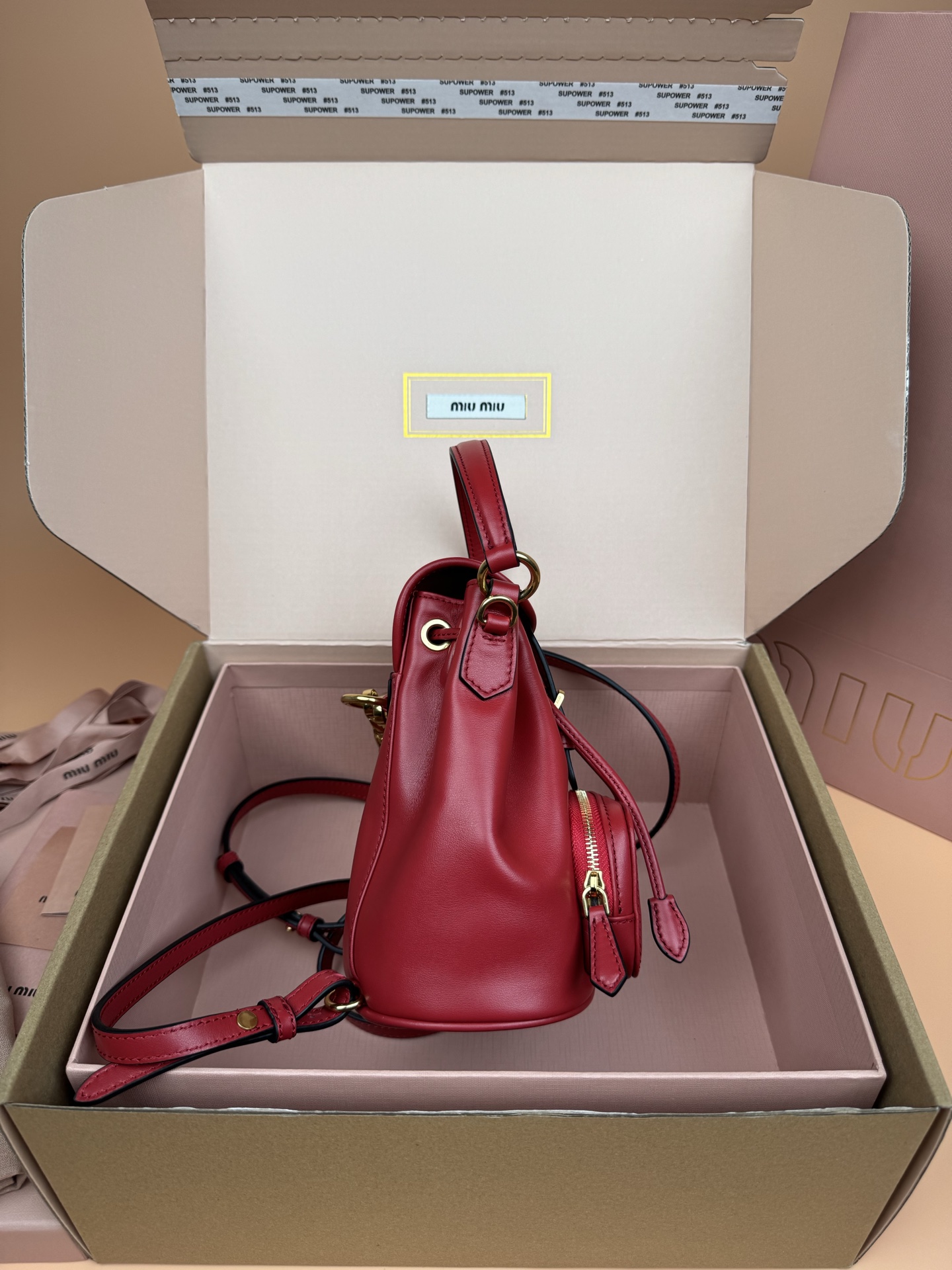 p860。【特级五金原厂皮】双肩包牛皮革～迷你大红

这款牛皮革双肩迷你背包采用校园风设计，让人想起童年，融合精湛工艺与休闲态度。别致的多口袋设计彰显品牌手袋的时尚趣致精神。.
尺寸:W15×H17.5×D10.5cm
編號：5BZ045