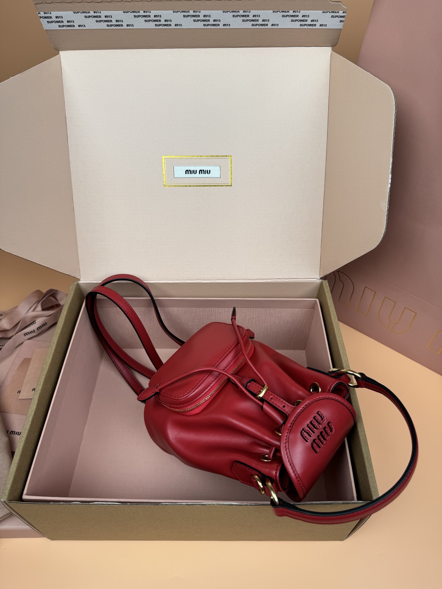 p860。【特级五金原厂皮】双肩包牛皮革～迷你大红

这款牛皮革双肩迷你背包采用校园风设计，让人想起童年，融合精湛工艺与休闲态度。别致的多口袋设计彰显品牌手袋的时尚趣致精神。.
尺寸:W15×H17.5×D10.5cm
編號：5BZ045