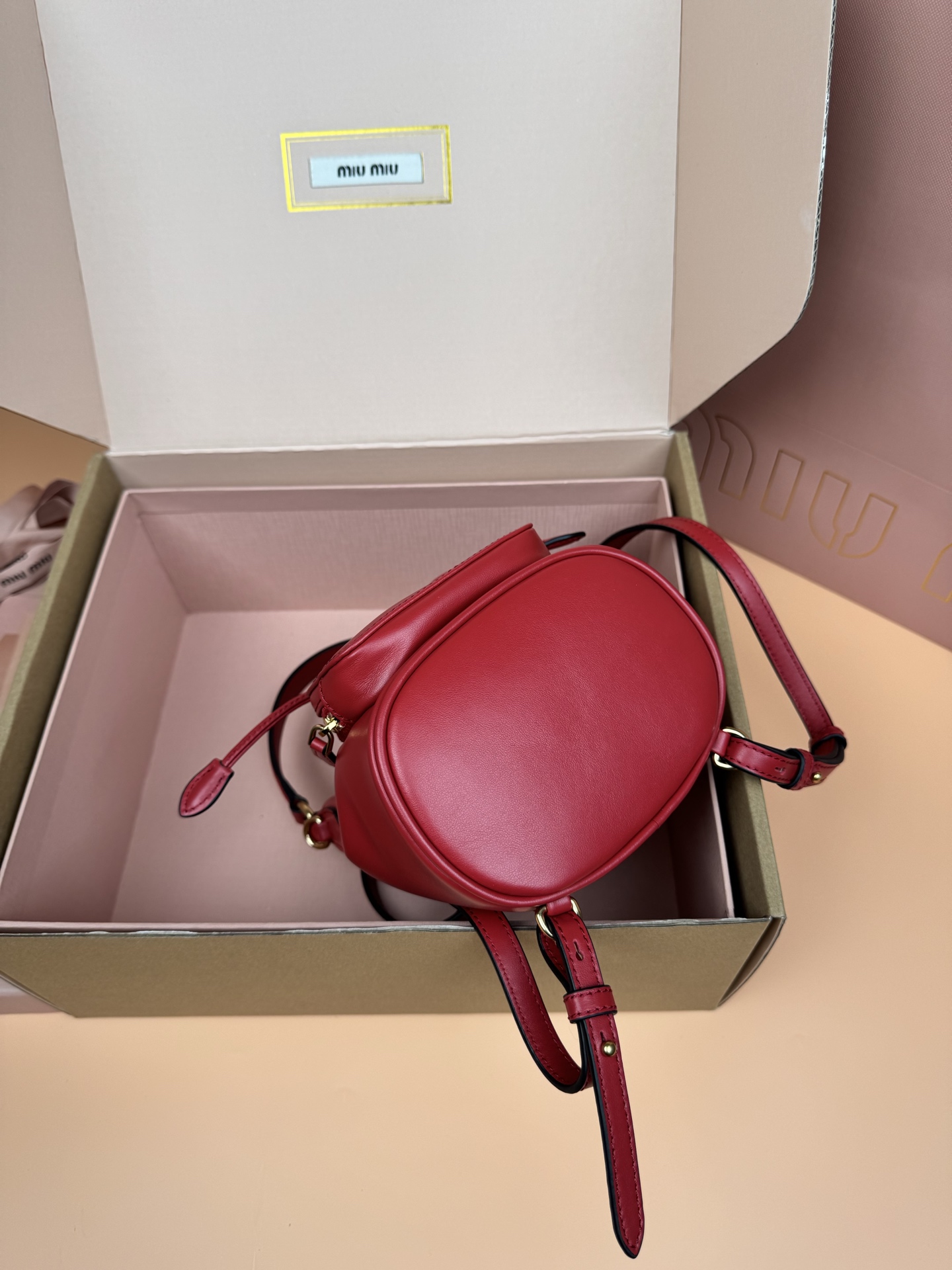 p860。【特级五金原厂皮】双肩包牛皮革～迷你大红

这款牛皮革双肩迷你背包采用校园风设计，让人想起童年，融合精湛工艺与休闲态度。别致的多口袋设计彰显品牌手袋的时尚趣致精神。.
尺寸:W15×H17.5×D10.5cm
編號：5BZ045