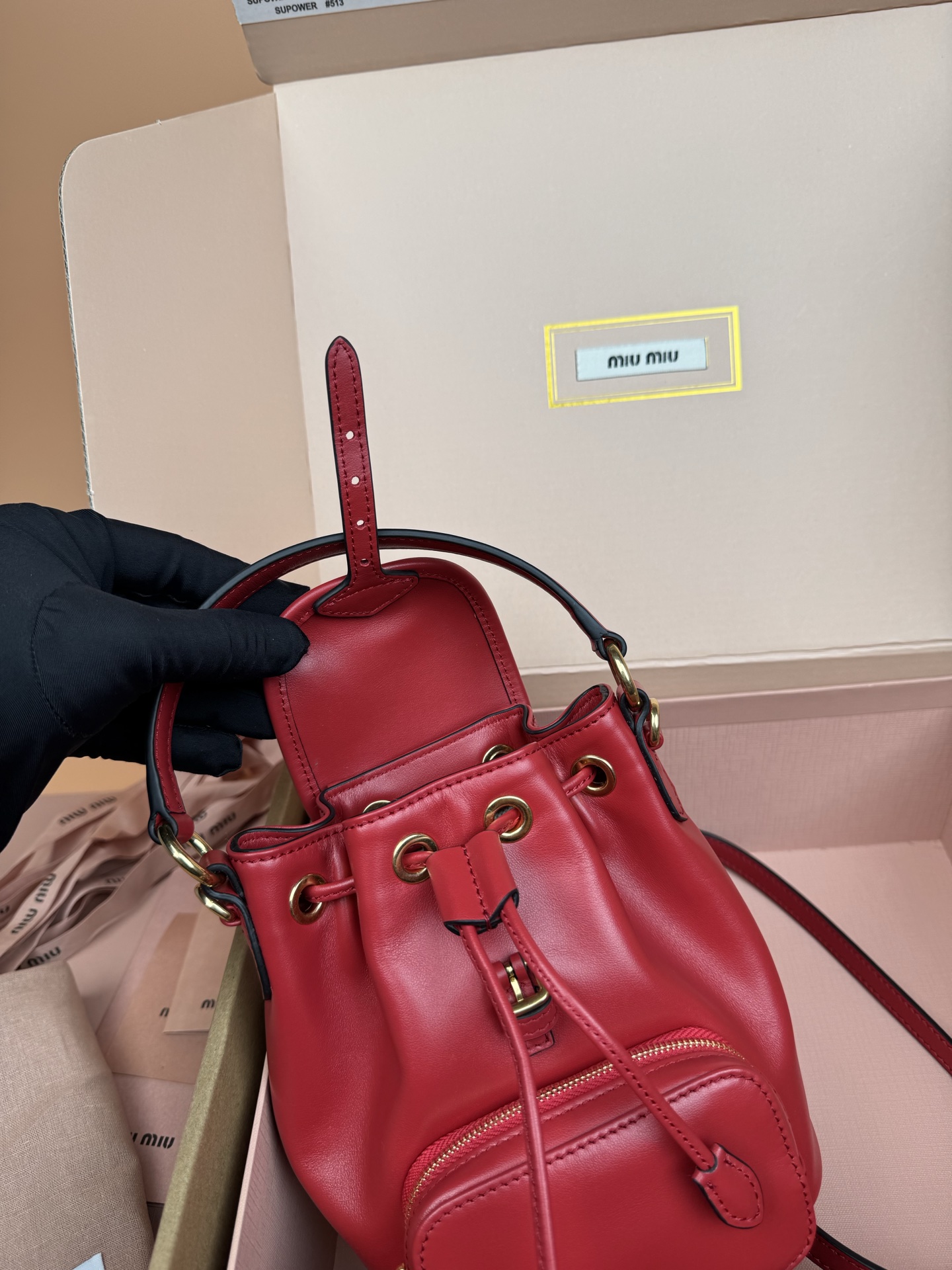 p860。【特级五金原厂皮】双肩包牛皮革～迷你大红

这款牛皮革双肩迷你背包采用校园风设计，让人想起童年，融合精湛工艺与休闲态度。别致的多口袋设计彰显品牌手袋的时尚趣致精神。.
尺寸:W15×H17.5×D10.5cm
編號：5BZ045