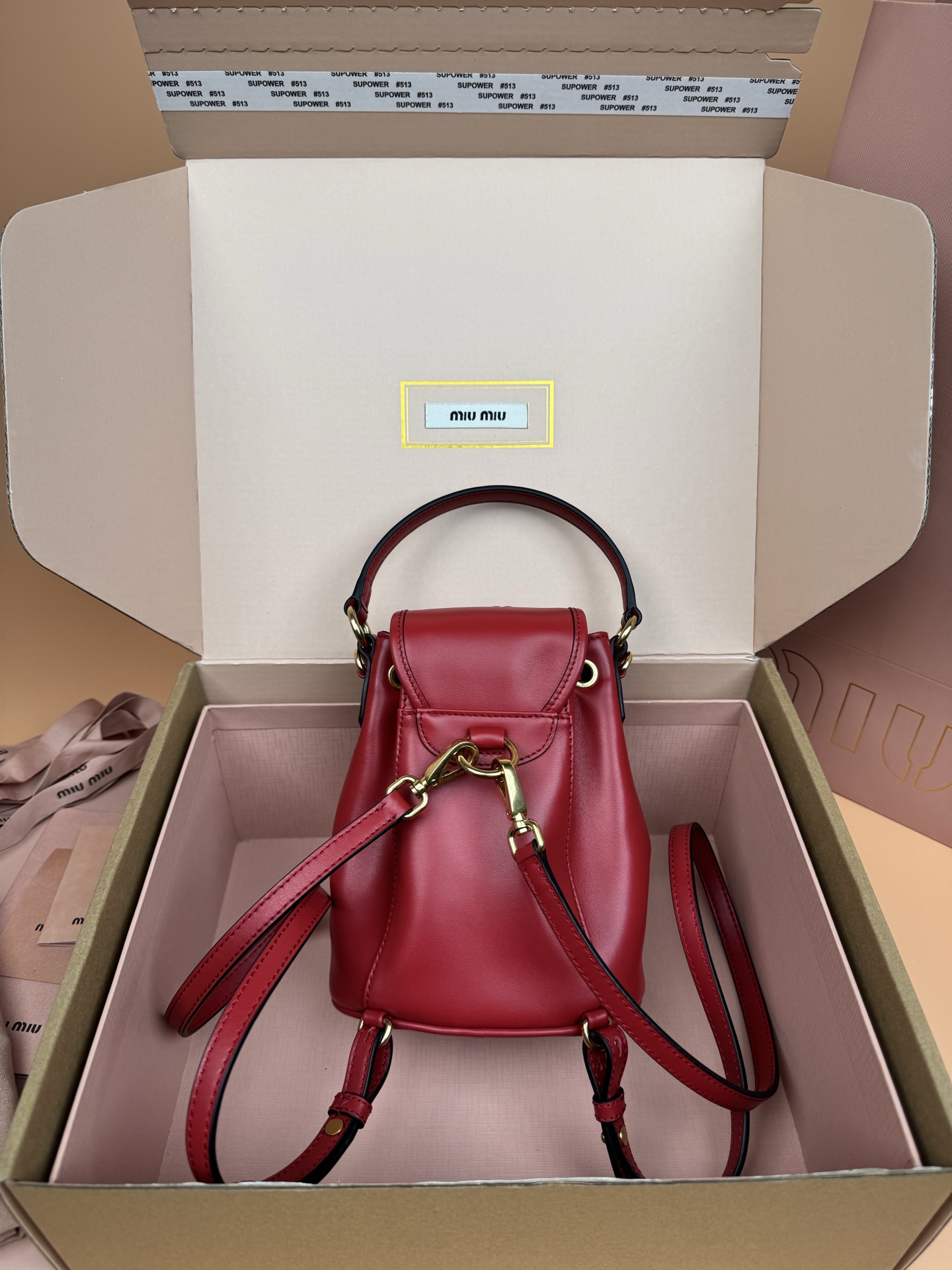 p860。【特级五金原厂皮】双肩包牛皮革～迷你大红

这款牛皮革双肩迷你背包采用校园风设计，让人想起童年，融合精湛工艺与休闲态度。别致的多口袋设计彰显品牌手袋的时尚趣致精神。.
尺寸:W15×H17.5×D10.5cm
編號：5BZ045