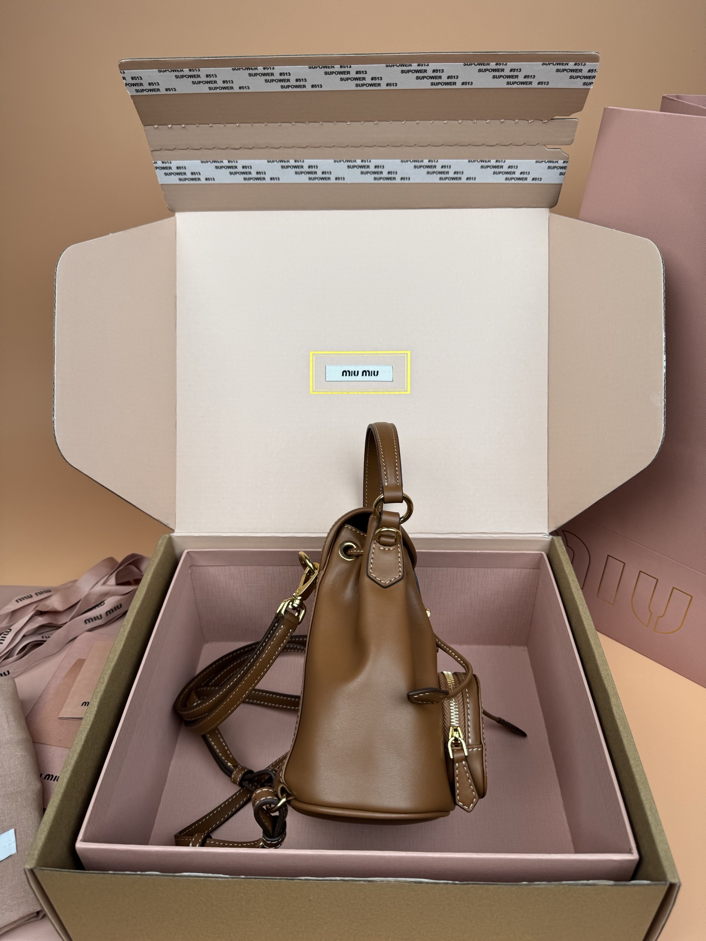 p860。【特级五金原厂皮】双肩包牛皮革～迷你干邑

这款牛皮革双肩迷你背包采用校园风设计，让人想起童年，融合精湛工艺与休闲态度。别致的多口袋设计彰显品牌手袋的时尚趣致精神。.
尺寸:W15×H17.5×D10.5cm
編號：5BZ045