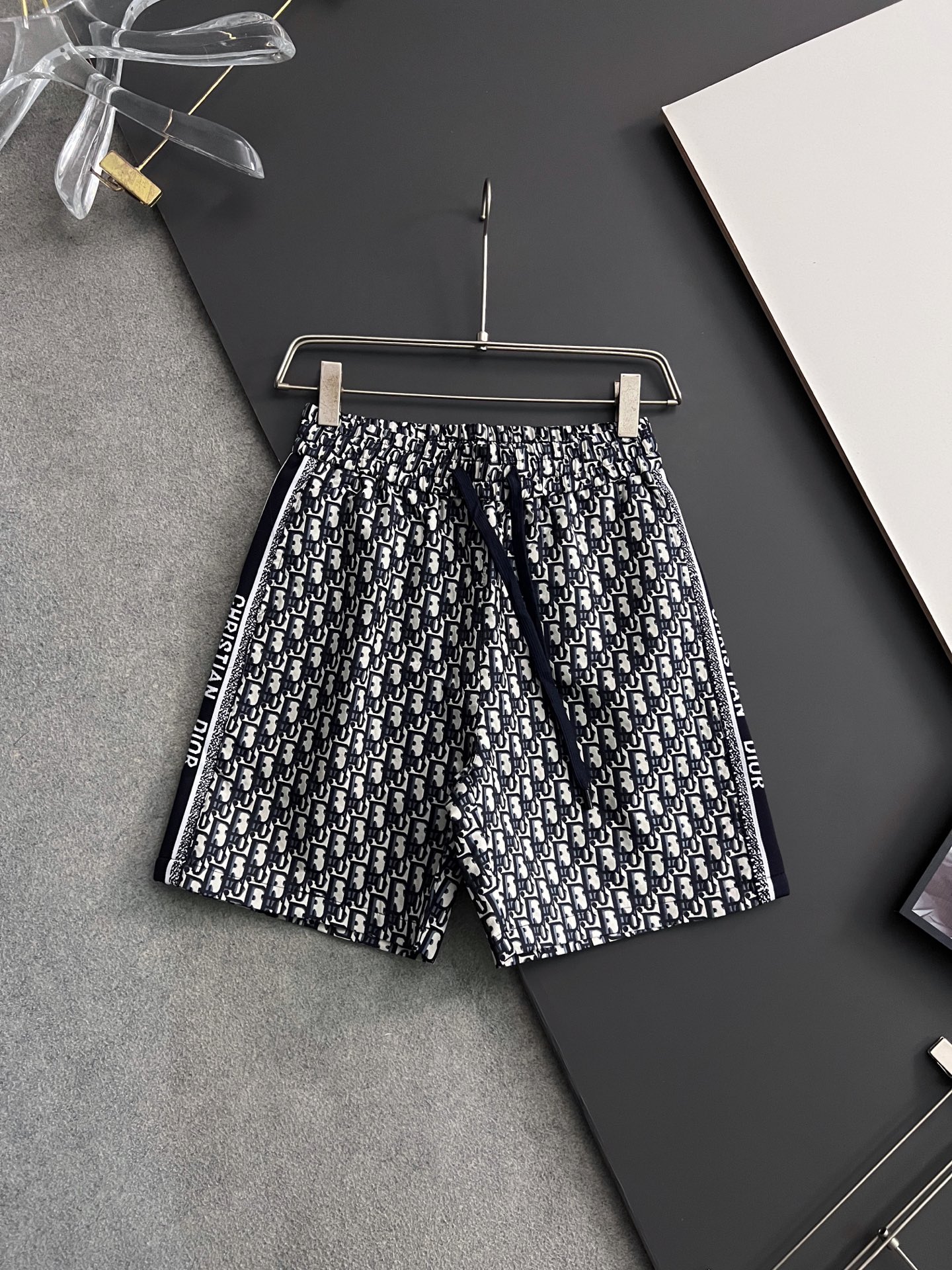 NO:162081,) CD25SS spring and summer new classic presbyopia pattern all-cotton drawstring shorts, men's side jacquard webbing splicing fashionable casual shorts cropped pants!  Trading companies have sparse channels and are released on the official website at the same time!  With its unique design concept and exquisite craftsmanship, these CD jacquard shorts have become a shining pearl in the fashion industry!  This shorts are made of customized cotton fabrics, which not only feels soft and comfortable, but also has good breathability and moisture absorption. Even in the hot summer, it can ensure that the wearer enjoys dryness and freedom!  The whole body of the shorts is covered with classic presbyopia patterns, which are carefully crafted through fine jacquard craftsmanship. Each needle and thread reveal the craftsman's attentiveness and concentration!  As the iconic element of the brand, the presbyterian pattern not only gives the shorts a strong retro charm, but also highlights the extraordinary taste and style of the wearer!  Striped webbing is cleverly spliced ​​on both sides of the shorts, which not only forms a sharp contrast with the presbyopia pattern, but also adds visual layering and dynamic!  At the same time, the brand's logo was exquisitely embroidered on the webbing. This detailed treatment not only improves the recognition of the shorts, but also allows the wearer to stand out among the crowd, demonstrating his personality and charm!  The waist of the trouser adopts a drawstring elastic design, which not only facilitates the wearer to adjust freely according to his own waistline, but also ensures the fit and comfort of the shorts!  The basic style cutting is not only simple and elegant, but also can well modify the body lines. Whether it is tall, short, fat, thin, you can easily control it and show your unique style!  Gray/blue, two colors into it!  Size M-3XL M size waist 70/76cm-Hip circumference 106cm-front 32cm-thigh circumference 64cm-thigh length 47cm L size waist 73/79cm-hip circumference 110cm-front 33cm-thigh circumference 66cm-thigh length 48cm XL size waist 76/82cm-hip circumference 114cm-front 34cm-thigh circumference 68cm-thigh length 49cm XXL size waist 80/86cm-thigh circumference 118cm-front 35cm-thigh circumference 71cm-thigh length 50cm 3XL size waist 84/90cm-thigh circumference 122cm-front 35cm-thigh circumference 74cm-thigh length 52cm Size recommended (standard version)  Height is 174-140 catties, it is suitable to try on the L size!  A boy can choose M code within 130 catties, a L code for 130-142 catties, a XL code for 142-154 catties, a XXL code for 154-166 catties, and a 3XL code for 166-180 catties!  ,,shorts,alexander wang19860909）CD25SS春夏新款经典老花图案全棉抽绳短裤,男士侧提花织带拼接时尚休闲短裤五分裤！贸易公司渠道稀出,同步官网发售！这款CD提花短裤,以其独特的设计理念和精湛的工艺,成为了时尚界的一颗璀璨明珠！ 这款短裤采用了客供定制的全棉面料,不仅触感柔软舒适,更具有良好的透气性和吸湿性,即便在炎炎夏日也能确保穿着者享受干爽与自在！短裤的通体被经典的老花图案所覆盖,这些图案通过精细的提花工艺精心打造,每一针每一线都透露着匠人的用心与专注！老花图案作为品牌的标志性元素,不仅赋予了短裤浓厚的复古韵味,更彰显出穿着者不凡的品味与格调！ 短裤的两侧巧妙地拼接了条纹织带,不仅与老花图案形成了鲜明的对比,更在视觉上增添了层次感和动感！同时织带上还精致地绣上了品牌的Logo,这一细节处理不仅提升了短裤的辨识度,更让穿着者在人群中脱颖而出,彰显个性与魅力！裤腰部分采用了抽绳松紧设计,不仅方便穿着者根据自身的腰围进行自由调节,更确保了短裤的贴合度与舒适度！基础版型裁剪,不仅简约大方,更能够很好地修饰身材线条,无论是高矮胖瘦,都能轻松驾驭,展现出自己的独特风采！灰色/蓝色,两色入！尺码M-3XL M码腰围70/76cm-臀围106cm-前档32cm-大腿围64cm-裤长47cm  L码腰围73/79cm-臀围110cm-前档33cm-大腿围66cm-裤长48cm  XL码腰围76/82cm-臀围114cm-前档34cm-大腿围68cm-裤长49cm  XXL码腰围80/86cm-臀围118cm-前档35cm-大腿围71cm-裤长50cm  3XL码腰围84/90cm-臀围122cm-前档35cm-大腿围74cm-裤长52cm 尺码推荐（标准版型） 身高174-140斤,试穿L码合适！ 男生体重130斤以内选择M码,130-142斤选择L码,142-154斤选择XL码,154-166斤选择XXL码,166-180斤选择3XL码！,,shorts,alexander wang,Men's clothing