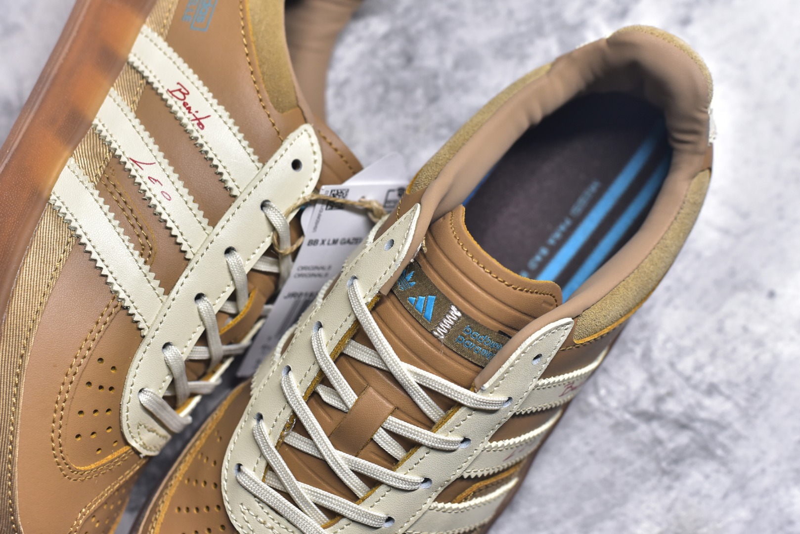 图片[9]-#坏痞兔Bad Bunny x AD Gazelle Indoor Trainers 联名羚羊内训系列低帮复古百搭休闲运动德训风板鞋 JR0182 Bad Bunny本人在杂志拍摄时率先上脚带一波节奏，emm，手上拿的杂志封面还是Kylie，看来前女友和布克重新约会，这位哥也还是没放下啊…回到鞋款本身，整体选择了简约的黑白皮革搭配浅灰色长绒麂皮材质，最后以半透明生胶大底收尾，质感在线。不同于以往联名的调色盘操作，Bad Bunny对Gazelle indoor进行了加宽加厚处理，以及鞋头变形的设计，带来全新的歪头面包鞋型Gazelle。此外，鞋款标签直接呈现在后跟处，鞋侧adidas标识下方还加入了\”benito\”字样，辨识度拉满。尺码：35.5-45-选品中心