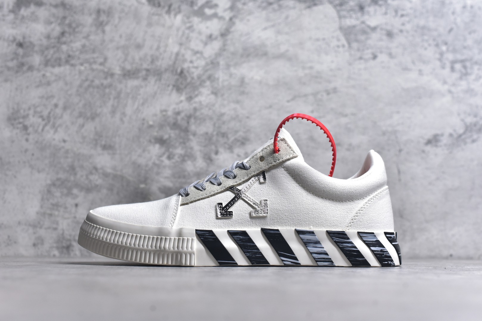 #Off-White c/o Virgil Abloh Vulc Low Top 箭头低帮硫化帆布板鞋 尺码：36 37 38 39 40 41 42 43 44 45 46 47 Off-White 近日才发布其春夏新款鞋履，紧跟着就推出全新秋冬鞋款。此番带来的是一系列“ Off-Court ”运动鞋，其中除了基础的黑、白色 Vulc Low-Top 还有一双充满街头韵味的棋盘格元素，亮点其实在鞋内侧的橙色瓶贴以及鞋带头的橙色细节处理。该品牌标志性的箭头标志，防盗扣和鞋带的设计以及鞋后跟的字样也极具“THE TEN”系列的影子。-选品中心