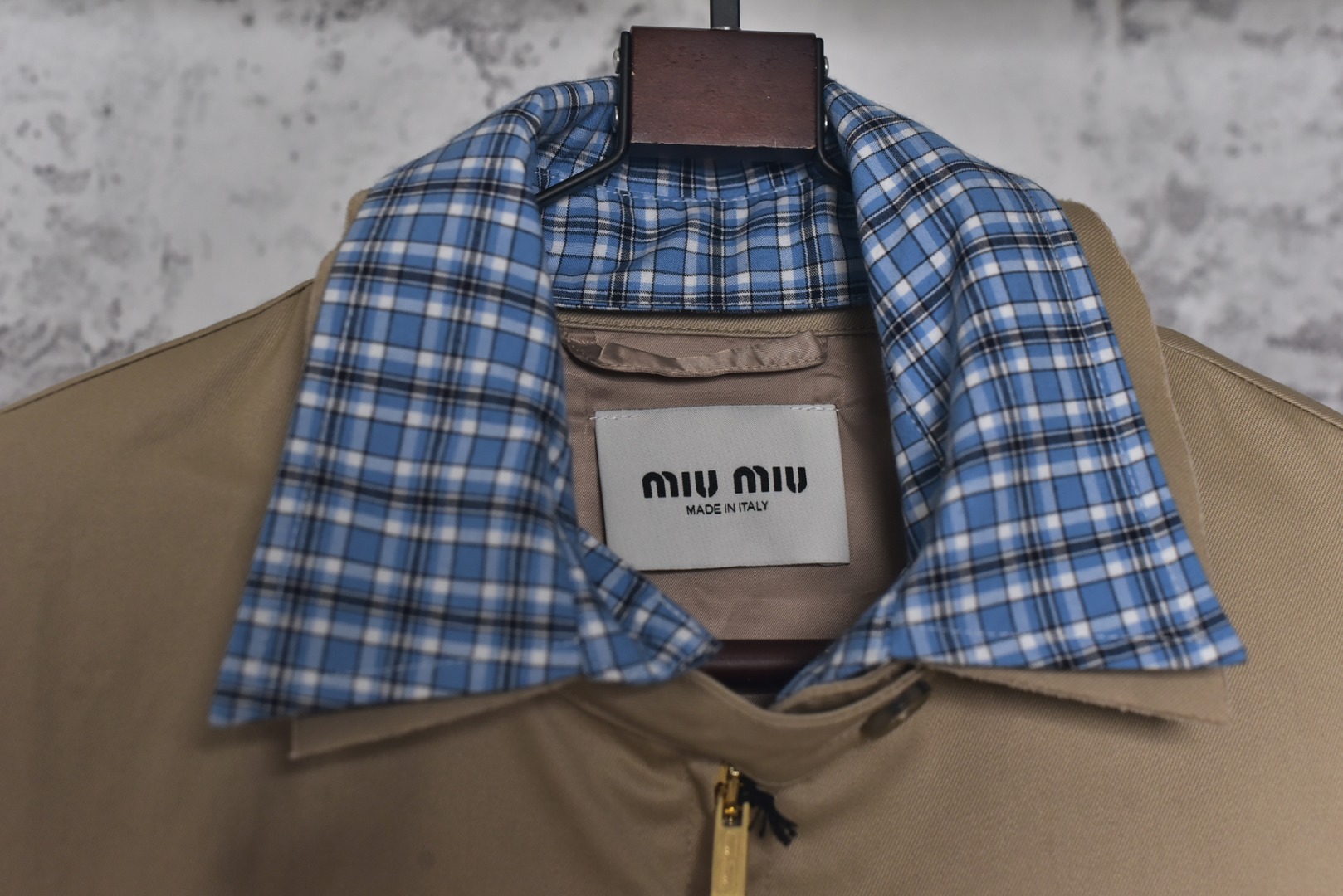图片[5]-#Miu Miu 25Fw Miu贴布绣格纹假两件夹克外套 定织定染高支数斜纹纺织，赋予面料硬挺的骨骼感与细腻的肌理触感。斜纹结构确保抗皱性与耐久度，同时通过微光泽后整理提升表面质感，呼应现代都市机能美学，选用19姆米级丝绸混纺内衬，以静电覆合技术贴合主体面料，实现无缝一体结构。丝质内里不仅提供亲肤透气性，更通过对比光泽强化内外层次差异，暗藏低调奢华感，复合式拼接设计，领口、袖口采用蓝格纹拼接设计，通过激光裁切包边工艺实现精准对格。拼接部位以隐藏式埋夹缝制衔接，边缘做0.3cm仿旧毛边处理，模拟自然磨损的复古效果，同时与主面料形成粗犷与精致的材质对话，定制镀金色五金拉链，选用日本YKK EXCELL系列底链，齿牙经PVD真空镀金处理，达到3级耐磨标准。拉头内部嵌入硅胶减震垫片，实现静音开合，表面做做旧蚀刻工艺呈现斑驳肌理，避免工业感过强，每颗纽扣取材于水牛角切片，经手工抛光保留天然纹理与半透光特性缠绕同色系绣线防止脱落，细节体现传统工艺与现代设计的融合 尺码：S-L【不拉拉链可以不用考虑体重】-选品中心