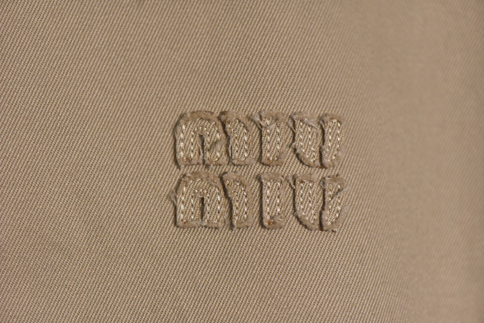 图片[3]-#Miu Miu 25Fw Miu贴布绣格纹假两件夹克外套 定织定染高支数斜纹纺织，赋予面料硬挺的骨骼感与细腻的肌理触感。斜纹结构确保抗皱性与耐久度，同时通过微光泽后整理提升表面质感，呼应现代都市机能美学，选用19姆米级丝绸混纺内衬，以静电覆合技术贴合主体面料，实现无缝一体结构。丝质内里不仅提供亲肤透气性，更通过对比光泽强化内外层次差异，暗藏低调奢华感，复合式拼接设计，领口、袖口采用蓝格纹拼接设计，通过激光裁切包边工艺实现精准对格。拼接部位以隐藏式埋夹缝制衔接，边缘做0.3cm仿旧毛边处理，模拟自然磨损的复古效果，同时与主面料形成粗犷与精致的材质对话，定制镀金色五金拉链，选用日本YKK EXCELL系列底链，齿牙经PVD真空镀金处理，达到3级耐磨标准。拉头内部嵌入硅胶减震垫片，实现静音开合，表面做做旧蚀刻工艺呈现斑驳肌理，避免工业感过强，每颗纽扣取材于水牛角切片，经手工抛光保留天然纹理与半透光特性缠绕同色系绣线防止脱落，细节体现传统工艺与现代设计的融合 尺码：S-L【不拉拉链可以不用考虑体重】-选品中心