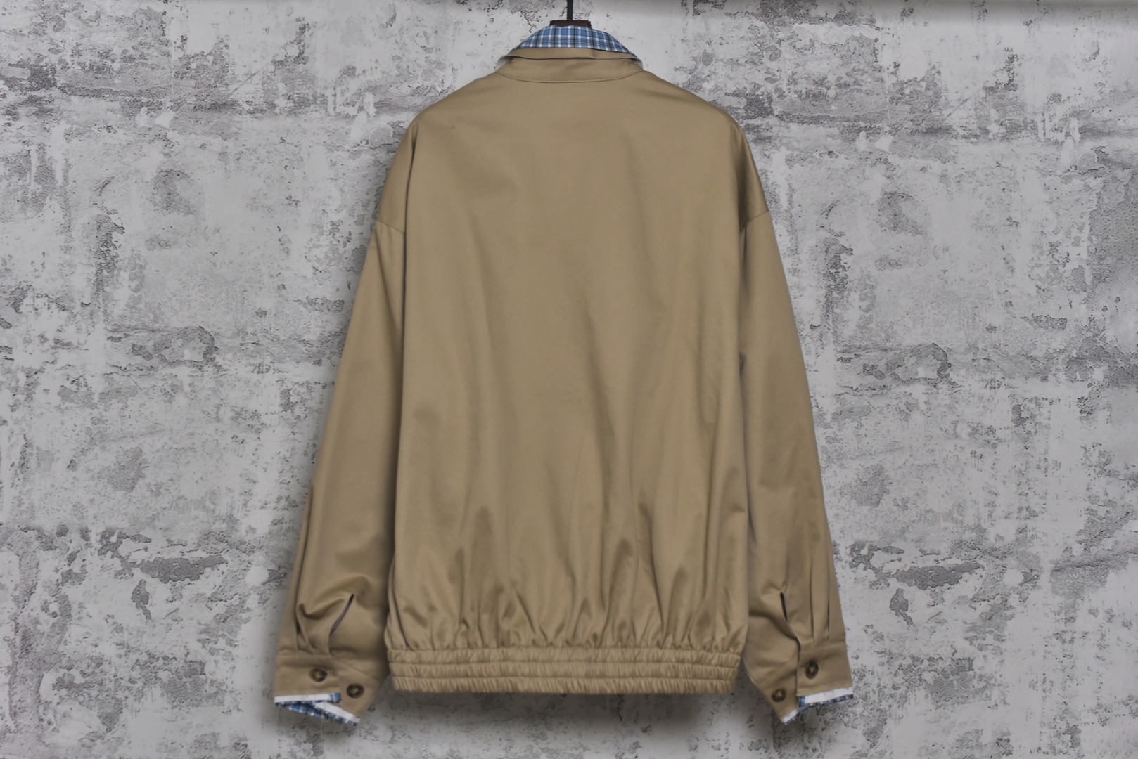 图片[2]-#Miu Miu 25Fw Miu贴布绣格纹假两件夹克外套 定织定染高支数斜纹纺织，赋予面料硬挺的骨骼感与细腻的肌理触感。斜纹结构确保抗皱性与耐久度，同时通过微光泽后整理提升表面质感，呼应现代都市机能美学，选用19姆米级丝绸混纺内衬，以静电覆合技术贴合主体面料，实现无缝一体结构。丝质内里不仅提供亲肤透气性，更通过对比光泽强化内外层次差异，暗藏低调奢华感，复合式拼接设计，领口、袖口采用蓝格纹拼接设计，通过激光裁切包边工艺实现精准对格。拼接部位以隐藏式埋夹缝制衔接，边缘做0.3cm仿旧毛边处理，模拟自然磨损的复古效果，同时与主面料形成粗犷与精致的材质对话，定制镀金色五金拉链，选用日本YKK EXCELL系列底链，齿牙经PVD真空镀金处理，达到3级耐磨标准。拉头内部嵌入硅胶减震垫片，实现静音开合，表面做做旧蚀刻工艺呈现斑驳肌理，避免工业感过强，每颗纽扣取材于水牛角切片，经手工抛光保留天然纹理与半透光特性缠绕同色系绣线防止脱落，细节体现传统工艺与现代设计的融合 尺码：S-L【不拉拉链可以不用考虑体重】-选品中心