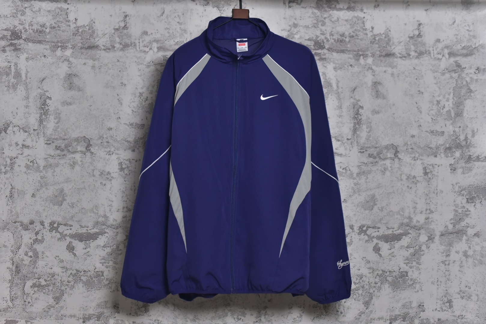 #Supreme 25ss 联名Swoosh图案立领夹克外套 三色全部购入原版开发，面料定织定染，25年春夏第4周，与Nike的联名系列中，此款运动夹克设计上融合了双方品牌的经典元素，同时注重材质与细节的质感，采用抗水涤纶面料，版型是宽松剪裁设计，背后印有大号Swoosh图案，3M反光细节提升夜间能见度，Supreme Logo以低调形式呈现（如袖口，口袋处），符合近年“克制设计”趋势，适合日常搭配，多色可选，复古与未来感并存，辅料全线独立开发，男女同款 尺码：M-XXL-选品中心