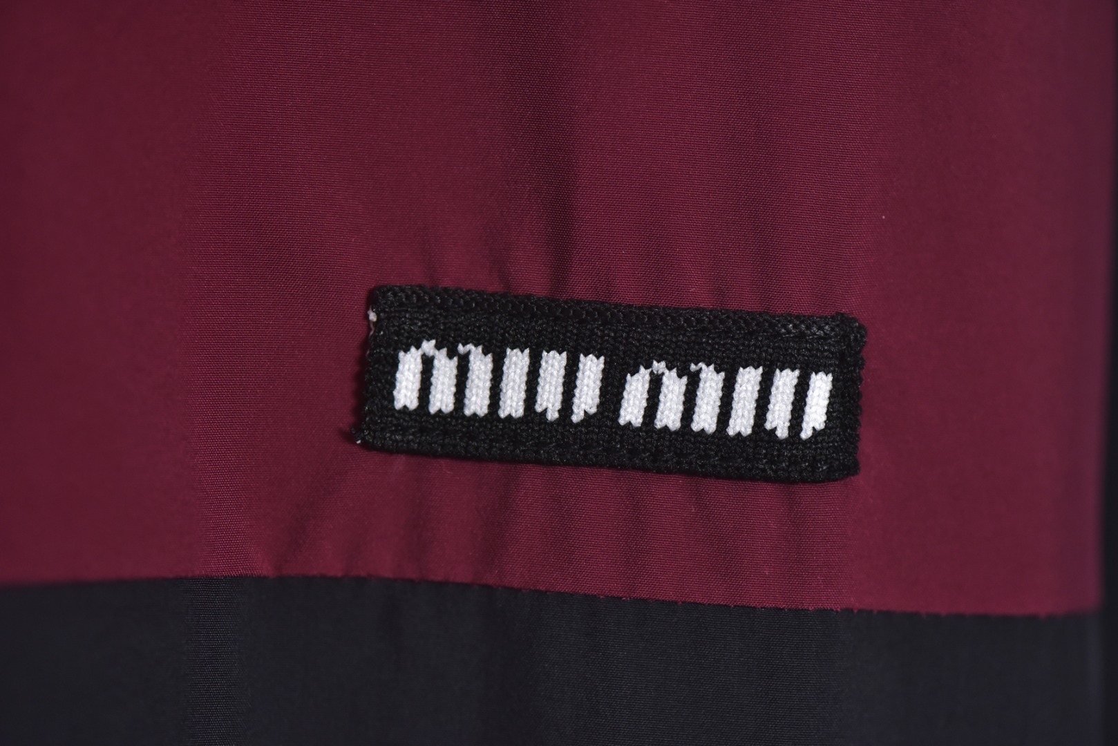 图片[4]-#Miu Miu 25Fw Miu小标拼色玫红连帽外套 梭织拼色主体，高密尼龙塔丝隆，采用30D/72超细旦纱线，经平纹+斜纹复合织造，表面做耐久防泼水涂层处理，可日常生活防水，激光切割拼缝，色块接缝处采用0.1mm级精密切割以热风压胶条，内衬加固。定制弹力捆条选用210T涤纶四面弹，经预缩处理后以45°斜裁包边，边缘采用三针五线收口，确保拉伸不变形，定织提花织带，以32股高强涤纶长丝织造，表面呈现MIUMIU专属提花Logo，通过纱罗组织实现透气镂空。米色动态调节抽绳，双通道抽绳管，可单手调节。绳扣内部设微型棘齿结构，防止运动中松动，采用立体冲孔网布，以5mm厚度+70%开孔率的聚酯单丝编织，背部复合吸湿速干氨纶，定制合金拉链，链齿采用亮光氧化锆陶瓷，拉头内嵌双轴承滑轮，顺滑度达20,000次测试无卡顿 尺码：44 46 48-选品中心