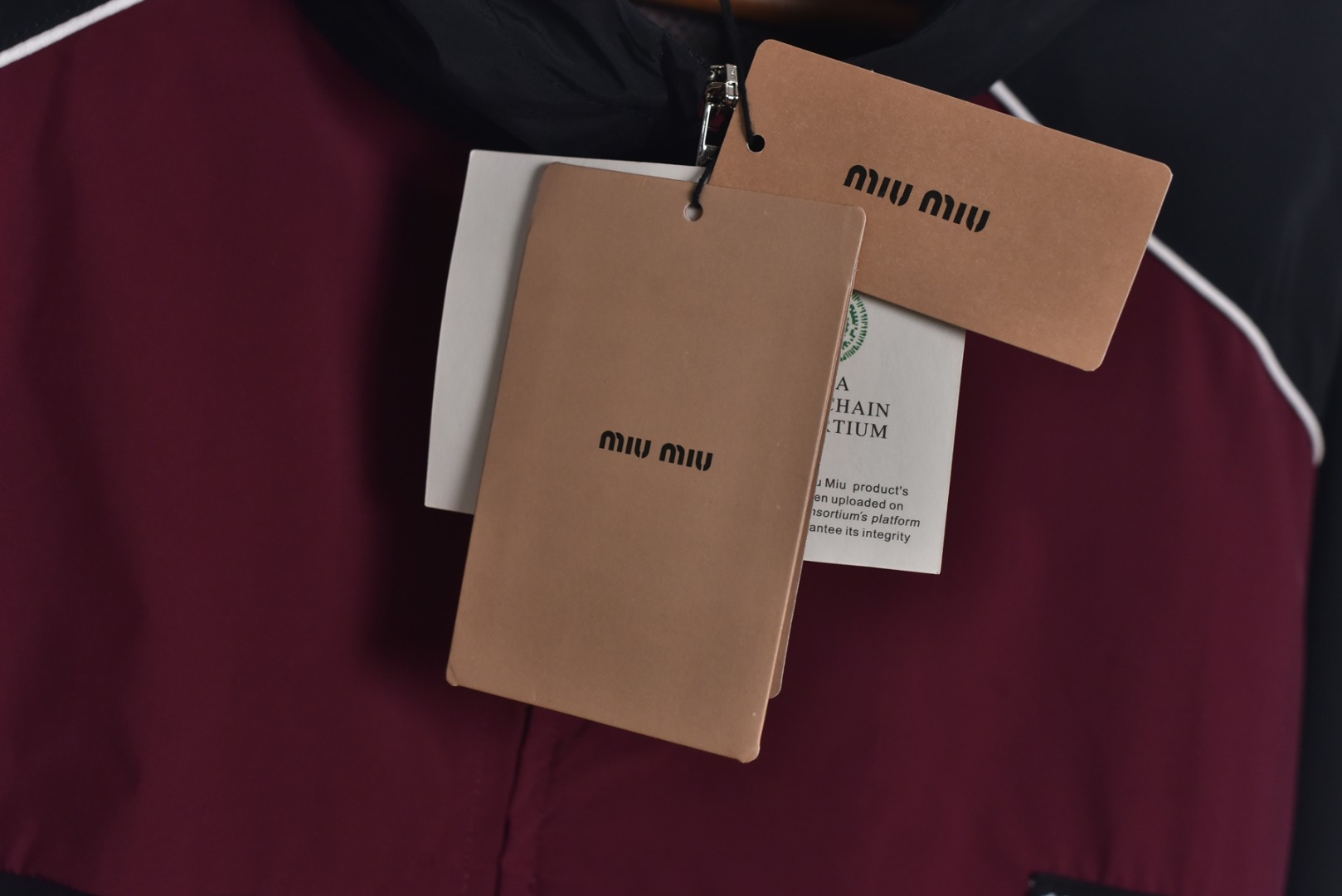 图片[7]-#Miu Miu 25Fw Miu小标拼色玫红连帽外套 梭织拼色主体，高密尼龙塔丝隆，采用30D/72超细旦纱线，经平纹+斜纹复合织造，表面做耐久防泼水涂层处理，可日常生活防水，激光切割拼缝，色块接缝处采用0.1mm级精密切割以热风压胶条，内衬加固。定制弹力捆条选用210T涤纶四面弹，经预缩处理后以45°斜裁包边，边缘采用三针五线收口，确保拉伸不变形，定织提花织带，以32股高强涤纶长丝织造，表面呈现MIUMIU专属提花Logo，通过纱罗组织实现透气镂空。米色动态调节抽绳，双通道抽绳管，可单手调节。绳扣内部设微型棘齿结构，防止运动中松动，采用立体冲孔网布，以5mm厚度+70%开孔率的聚酯单丝编织，背部复合吸湿速干氨纶，定制合金拉链，链齿采用亮光氧化锆陶瓷，拉头内嵌双轴承滑轮，顺滑度达20,000次测试无卡顿 尺码：44 46 48-选品中心