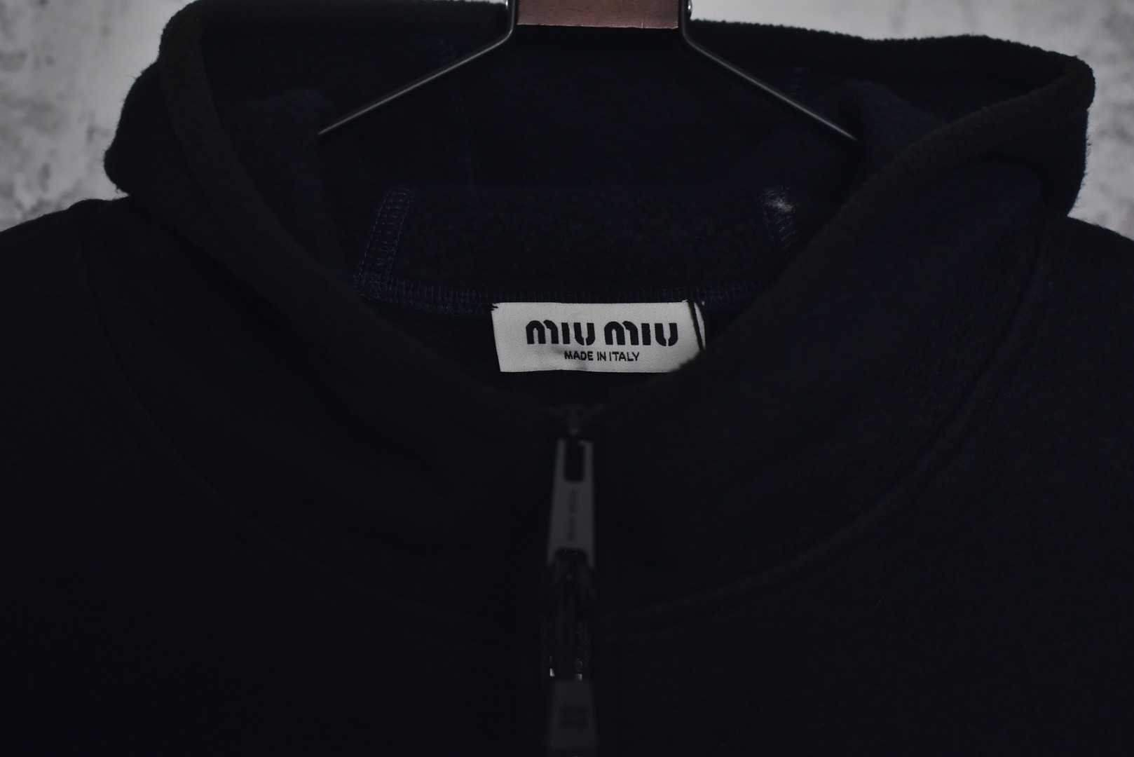 图片[6]-#Miu Miu 25Fw Miu小标摇粒绒连帽外套 面料采用定制织造染整一体工艺，从纱线选配到染色均按品牌标准定制。400克重摇粒绒需平衡蓬松度与垂感，通过经纬密优化确保厚度一致且抗风保暖。色牢度控制：定染环节采用环保活性染料，经5次水洗测试确保色彩零偏差，实现桃粉、薄荷绿等高饱和度色调的纯净度。肌理处理：双刷双摇工艺打造绒毛丰盈且定向倒伏的立体质感，避免传统摇粒绒的臃肿感。全件拉链及配件均为开模定制，非市场公版零件。拉链齿工艺：采用哑光涂层YKK EXCELLA系列，顺滑度与耐久度超越工业标准，拉头内部结构加入消音硅脂。挂绳挂件设计：拉链片与挂绳采用超声波切割无缝拼接，尾端缀以激光雕刻Miu Logo的锌合金吊坠，单挂件经历12道冲压打磨工序。装饰刺绣均采用进口田岛多针头绣花机完成。3D立体绣法：先以平绣打底，再叠加链目绣与毛巾绣混合工艺，使图案凸起高度达1.2mm，触感柔软不硌肤。本品以工艺冗余度换取极致体验，从纱线定制到终端装配均执行高精度标准，将功能性细节转化为隐性奢华，重构时尚单品的价值维度 尺码：S-L-选品中心