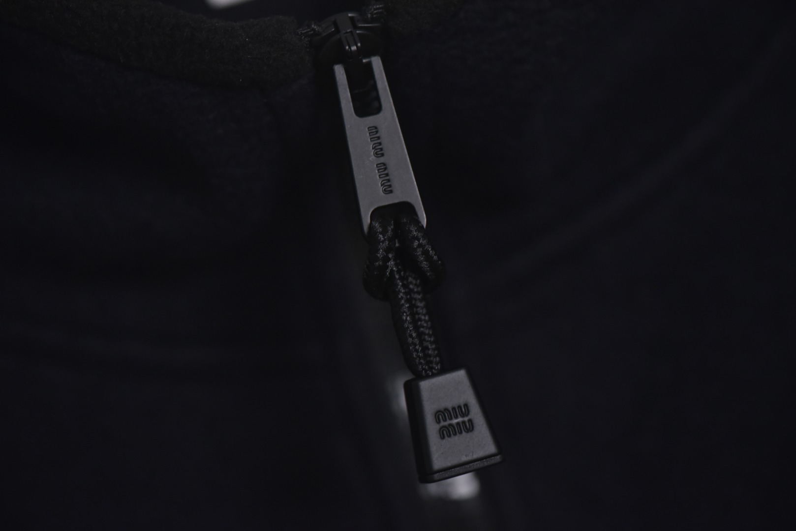 图片[4]-#Miu Miu 25Fw Miu小标摇粒绒连帽外套 面料采用定制织造染整一体工艺，从纱线选配到染色均按品牌标准定制。400克重摇粒绒需平衡蓬松度与垂感，通过经纬密优化确保厚度一致且抗风保暖。色牢度控制：定染环节采用环保活性染料，经5次水洗测试确保色彩零偏差，实现桃粉、薄荷绿等高饱和度色调的纯净度。肌理处理：双刷双摇工艺打造绒毛丰盈且定向倒伏的立体质感，避免传统摇粒绒的臃肿感。全件拉链及配件均为开模定制，非市场公版零件。拉链齿工艺：采用哑光涂层YKK EXCELLA系列，顺滑度与耐久度超越工业标准，拉头内部结构加入消音硅脂。挂绳挂件设计：拉链片与挂绳采用超声波切割无缝拼接，尾端缀以激光雕刻Miu Logo的锌合金吊坠，单挂件经历12道冲压打磨工序。装饰刺绣均采用进口田岛多针头绣花机完成。3D立体绣法：先以平绣打底，再叠加链目绣与毛巾绣混合工艺，使图案凸起高度达1.2mm，触感柔软不硌肤。本品以工艺冗余度换取极致体验，从纱线定制到终端装配均执行高精度标准，将功能性细节转化为隐性奢华，重构时尚单品的价值维度 尺码：S-L-选品中心