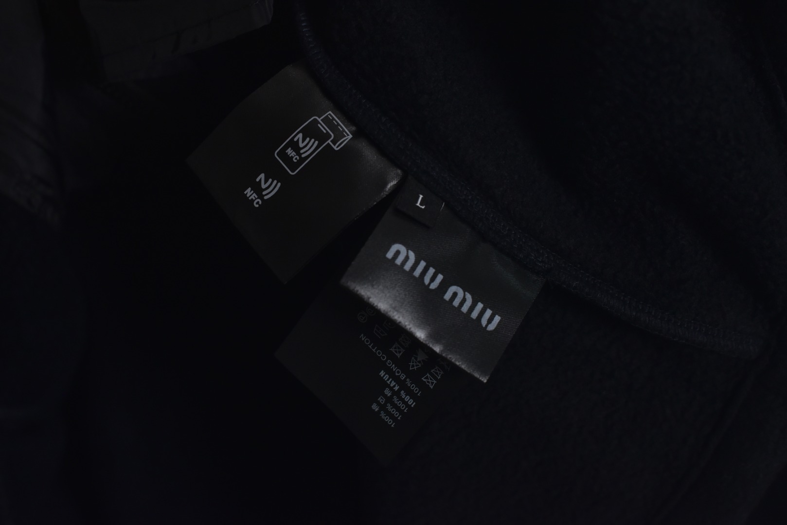 图片[9]-#Miu Miu 25Fw Miu小标摇粒绒连帽外套 面料采用定制织造染整一体工艺，从纱线选配到染色均按品牌标准定制。400克重摇粒绒需平衡蓬松度与垂感，通过经纬密优化确保厚度一致且抗风保暖。色牢度控制：定染环节采用环保活性染料，经5次水洗测试确保色彩零偏差，实现桃粉、薄荷绿等高饱和度色调的纯净度。肌理处理：双刷双摇工艺打造绒毛丰盈且定向倒伏的立体质感，避免传统摇粒绒的臃肿感。全件拉链及配件均为开模定制，非市场公版零件。拉链齿工艺：采用哑光涂层YKK EXCELLA系列，顺滑度与耐久度超越工业标准，拉头内部结构加入消音硅脂。挂绳挂件设计：拉链片与挂绳采用超声波切割无缝拼接，尾端缀以激光雕刻Miu Logo的锌合金吊坠，单挂件经历12道冲压打磨工序。装饰刺绣均采用进口田岛多针头绣花机完成。3D立体绣法：先以平绣打底，再叠加链目绣与毛巾绣混合工艺，使图案凸起高度达1.2mm，触感柔软不硌肤。本品以工艺冗余度换取极致体验，从纱线定制到终端装配均执行高精度标准，将功能性细节转化为隐性奢华，重构时尚单品的价值维度 尺码：S-L-选品中心