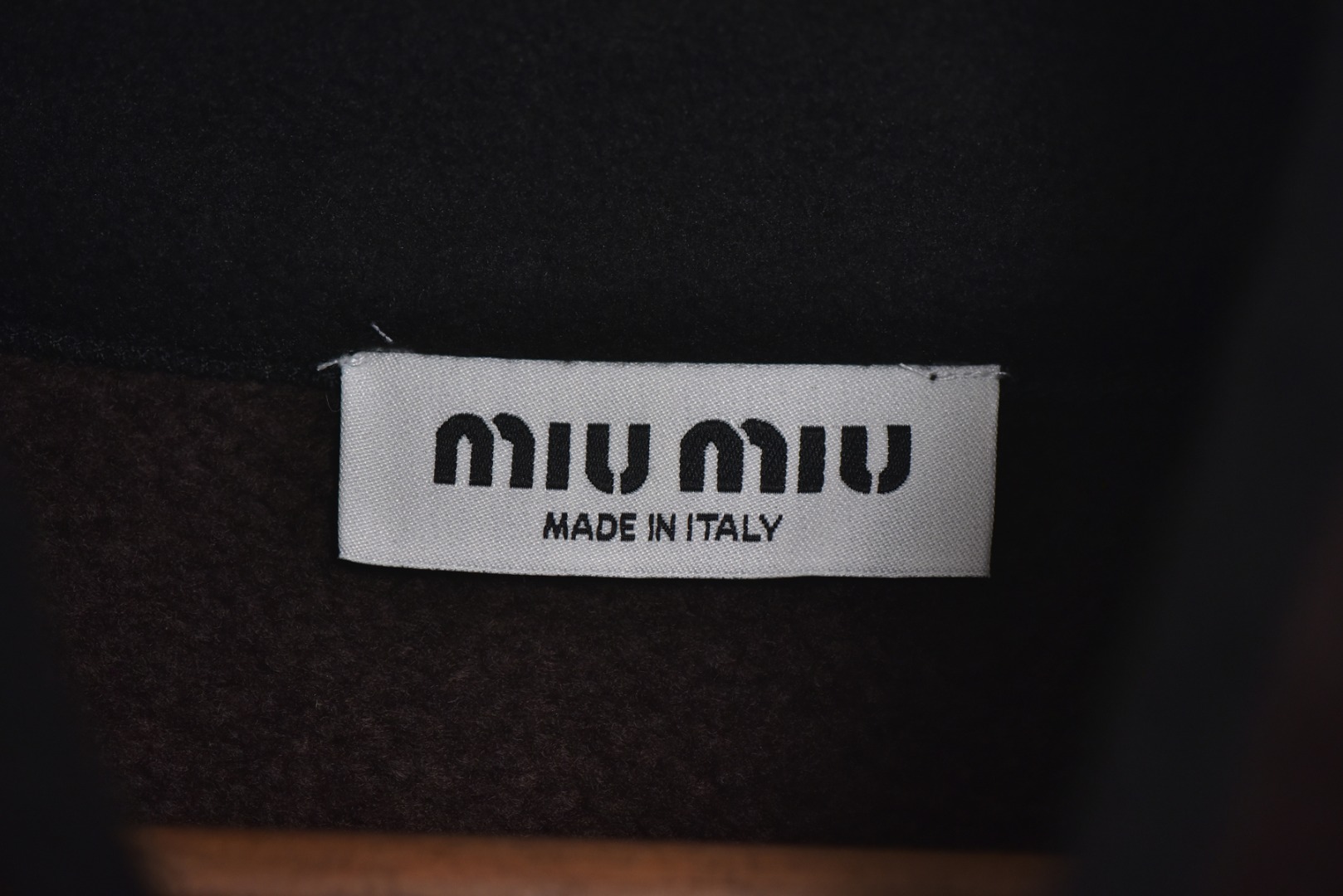 图片[4]-#Miu Miu 25Fw Miu小标咖色摇粒绒立领外套 面料采用定制织造染整一体工艺，从纱线选配到染色均按品牌标准定制。400克重摇粒绒需平衡蓬松度与垂感，通过经纬密优化确保厚度一致且抗风保暖。色牢度控制：定染环节采用环保活性染料，经5次水洗测试确保色彩零偏差，实现桃粉、薄荷绿等高饱和度色调的纯净度。肌理处理：双刷双摇工艺打造绒毛丰盈且定向倒伏的立体质感，避免传统摇粒绒的臃肿感。全件拉链及配件均为开模定制，非市场公版零件。拉链齿工艺：采用哑光涂层YKK EXCELLA系列，顺滑度与耐久度超越工业标准，拉头内部结构加入消音硅脂。挂绳挂件设计：拉链片与挂绳采用超声波切割无缝拼接，尾端缀以激光雕刻Logo的锌合金吊坠，单挂件经历12道冲压打磨工序。装饰刺绣均采用田岛多针头绣花机完成。3D立体绣法：先以平绣打底，再叠加链目绣与毛巾绣混合工艺，使图案凸起高度达1.2mm，触感柔软不硌肤。本品以工艺冗余度换取极致体验，从纱线定制到终端装配均执行高精度标准，将功能性细节转化为隐性奢华，重构时尚单品的价值维度 尺码：S-L-选品中心