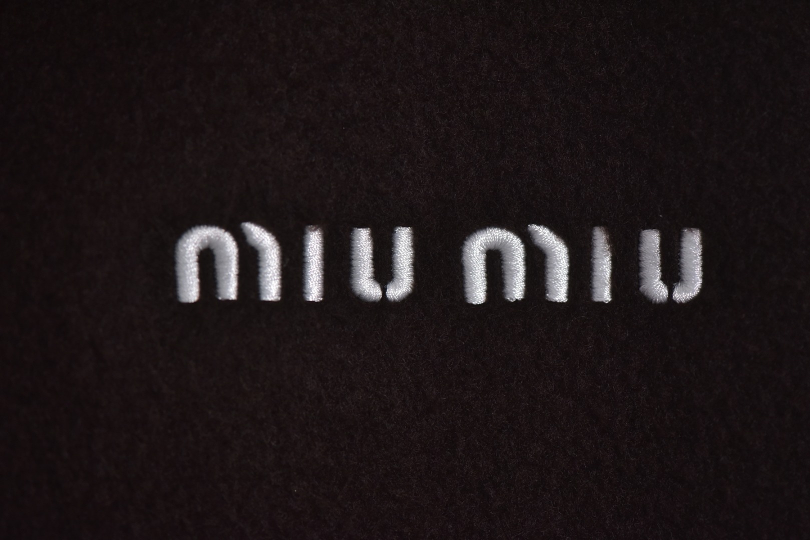 图片[3]-#Miu Miu 25Fw Miu小标咖色摇粒绒立领外套 面料采用定制织造染整一体工艺，从纱线选配到染色均按品牌标准定制。400克重摇粒绒需平衡蓬松度与垂感，通过经纬密优化确保厚度一致且抗风保暖。色牢度控制：定染环节采用环保活性染料，经5次水洗测试确保色彩零偏差，实现桃粉、薄荷绿等高饱和度色调的纯净度。肌理处理：双刷双摇工艺打造绒毛丰盈且定向倒伏的立体质感，避免传统摇粒绒的臃肿感。全件拉链及配件均为开模定制，非市场公版零件。拉链齿工艺：采用哑光涂层YKK EXCELLA系列，顺滑度与耐久度超越工业标准，拉头内部结构加入消音硅脂。挂绳挂件设计：拉链片与挂绳采用超声波切割无缝拼接，尾端缀以激光雕刻Logo的锌合金吊坠，单挂件经历12道冲压打磨工序。装饰刺绣均采用田岛多针头绣花机完成。3D立体绣法：先以平绣打底，再叠加链目绣与毛巾绣混合工艺，使图案凸起高度达1.2mm，触感柔软不硌肤。本品以工艺冗余度换取极致体验，从纱线定制到终端装配均执行高精度标准，将功能性细节转化为隐性奢华，重构时尚单品的价值维度 尺码：S-L-选品中心
