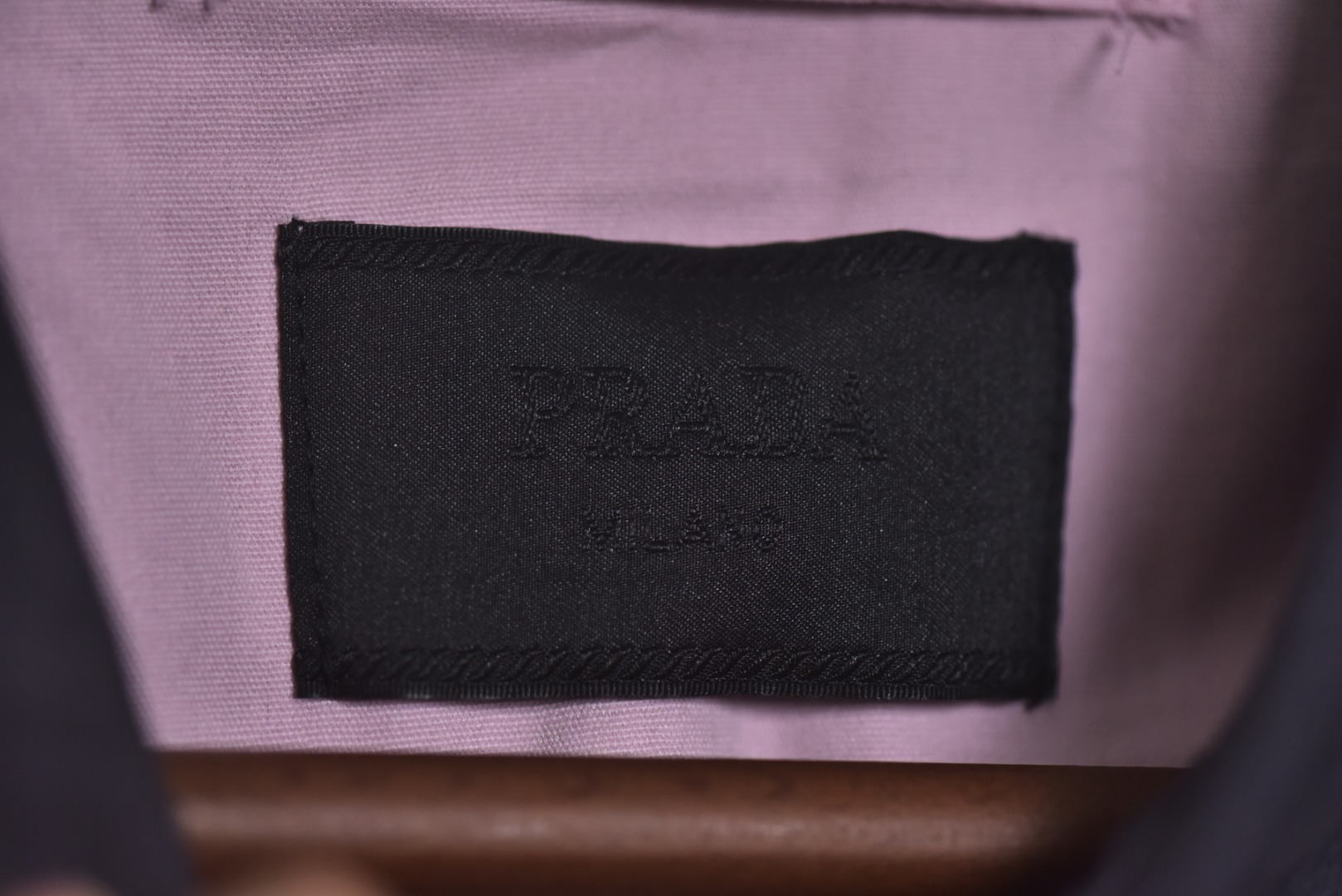 图片[4]-#Prada/普拉达 25Fw 小标灰粉夹克外套 定织高支高密的全工艺梭织面料，经纱与纬纱均采用精梳长绒棉与微量高科技聚酯纤维混纺，通过调整织机参数和纱线张力，使面料呈现出细腻、致密且硬挺的质感。其表面有极其细微的肌理感，而非普通面料的平淡光泽。这种密度确保了夹克廓形的立挺度与持久性，久穿不易变形。定染面料，“哈灵顿灰粉” 并非普通的粉灰色，而是经过多次校色实验的复合色调。在灰色的冷峻基调中，精准注入了一抹低饱和度的粉彩，形成了冷静克制与温柔浪漫的独特冲突感。染料采用进口环保染料，经过先染后整的工艺，色牢度极高，颜色渗透至纤维内核，确保了色彩的持久与均匀，杜绝了廉价面料的浮色感。“重机”JUKI专业缝纫设备。使用特定针距确保线迹均匀、牢固且美观。接缝均采用包边处理，完全看不到毛边，关键受力点均进行二次打结或强化，极大提升了耐用性。使用田岛多头电子刺绣机，以超过每分钟1000转的高速和0.1mm的精度还原，每一个字母的转角、弧线的边缘都清晰锐利，无任何锯齿感。定制辅料三标，男女同款 尺码：48 50 52-选品中心