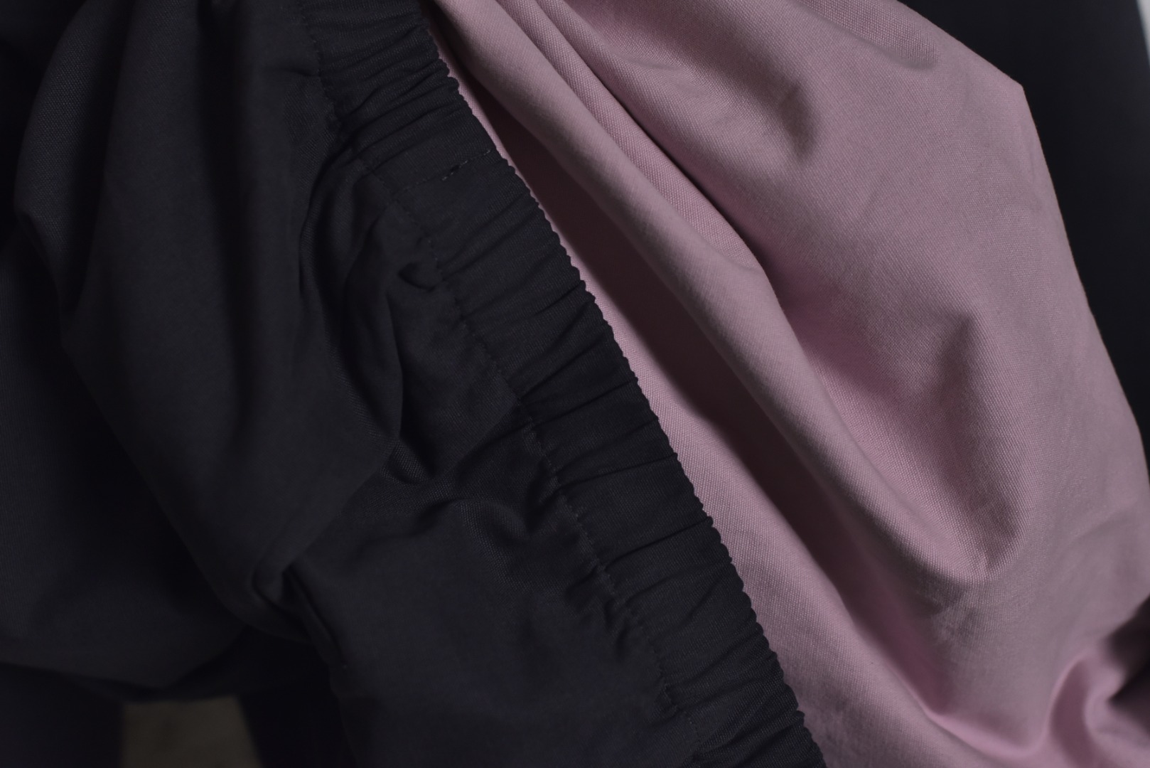 图片[9]-#Prada/普拉达 25Fw 小标灰粉夹克外套 定织高支高密的全工艺梭织面料，经纱与纬纱均采用精梳长绒棉与微量高科技聚酯纤维混纺，通过调整织机参数和纱线张力，使面料呈现出细腻、致密且硬挺的质感。其表面有极其细微的肌理感，而非普通面料的平淡光泽。这种密度确保了夹克廓形的立挺度与持久性，久穿不易变形。定染面料，“哈灵顿灰粉” 并非普通的粉灰色，而是经过多次校色实验的复合色调。在灰色的冷峻基调中，精准注入了一抹低饱和度的粉彩，形成了冷静克制与温柔浪漫的独特冲突感。染料采用进口环保染料，经过先染后整的工艺，色牢度极高，颜色渗透至纤维内核，确保了色彩的持久与均匀，杜绝了廉价面料的浮色感。“重机”JUKI专业缝纫设备。使用特定针距确保线迹均匀、牢固且美观。接缝均采用包边处理，完全看不到毛边，关键受力点均进行二次打结或强化，极大提升了耐用性。使用田岛多头电子刺绣机，以超过每分钟1000转的高速和0.1mm的精度还原，每一个字母的转角、弧线的边缘都清晰锐利，无任何锯齿感。定制辅料三标，男女同款 尺码：48 50 52-选品中心