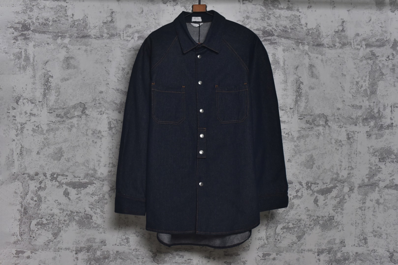 #Dior/迪奥 25Fw D皮标蓝斜纹牛仔衬衫外套 采用海军蓝色轻盈棉质斜纹面料制作，确保了穿着舒适性与耐用性的统一，具备良好的抗皱性和耐久性，此色彩的表现趋向于沉稳而不沉闷，简约口袋设计，此款保持了简洁的线条和结构，避免了过多装饰带来的繁复感，背面饰有皮革标牌，彰显品牌身份的同时，也体现了品牌对低调的极致追求，展现了克制的品牌展示方式，这种隐晦的标志设计，让懂得欣赏的人一眼便能识别其品质，而不至于显得过于张扬，采用实用版型设计，宽松而不臃肿的剪裁，适合多种身材穿着，既保证了舒适度，又确保了轮廓的优雅，搭配简约裤型产品，塑造干练而不失温和的专业形象，既能应对稍正式的场合，又不会显得过于刻意，这种搭配平衡了衬衫和外套的休闲感与场合需要的得体度，定制辅料三标，男女同款 尺码：39/S 40/M 41/L 42/XL-选品中心