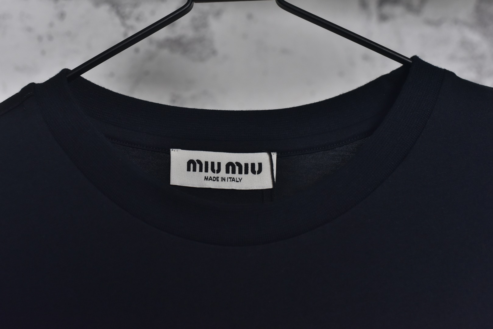 图片[4]-#Miu Miu 25Fw Miu小标刺绣长袖 采用高品级24支精梳棉纱线，通过「先染后织」工艺确保色彩均匀性，纱线经双股加捻提升抗起球性，布面光洁度优于普通棉织物，对版190克重精密调控：通过18针细针距圆机编织，兼顾垂坠感与挺括性，需配合恒温恒湿车间避免纱线张力波动，紧密纺结构：借鉴瑞士立达紧密纺技术，纱线毛羽减少60%，织物密度达156针/英寸²，实现婴儿肌肤触感的同时保持8%以上的弹性回复率，采用日本FIL-TEC刺绣专用涤纶线，实用进口田岛机设备，确保每英寸12针的高密度刺绣图案边缘无毛刺，底层先以水溶衬定位，中层填充天丝垫纱，表层以雕孔绣工艺打造空气感立体效果，定制辅料三标，男女同款 尺码：XS-M-选品中心