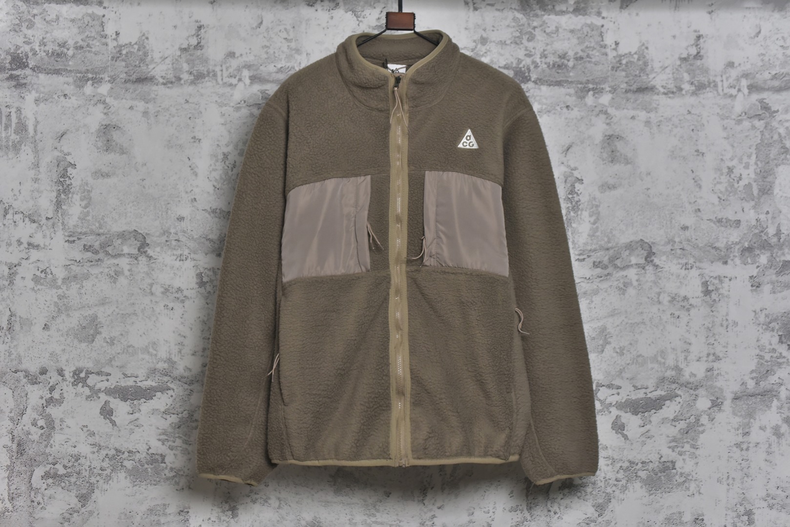 #Nike 25Fw ACG小标羊羔绒外套 采用定染羊羔绒面料，原版拆分分解，同步定织面料，胸前以及两侧均设有口袋设计，满足ACG系列户外基本穿着需求，多处YKK5号双头拉链，开模凹凸一致ACG主标吊牌，内里全包边处理，细节用心跟足原版，条码洗唛主标包装全部一致，原版版型一致，偏OS宽松版型，男女通穿，包容性强，黑色与卡其色两种经典配色，满足不同风格需求。高品质的材料与工艺确保了产品的耐用性和舒适度，无论是都市日常穿搭还是户外活动，这款外套都能让你在保持风格的同时享受温暖，男女同款 尺码：M-XXL-选品中心