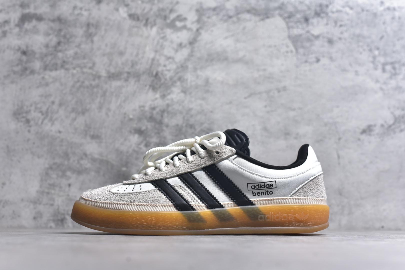 #坏痞兔Bad Bunny x AD Gazelle Indoor Trainers 联名羚羊内训系列低帮复古百搭休闲运动德训风板鞋 IF9735 Bad Bunny本人在杂志拍摄时率先上脚带一波节奏，emm，手上拿的杂志封面还是Kylie，看来前女友和布克重新约会，这位哥也还是没放下啊...回到鞋款本身，整体选择了简约的黑白皮革搭配浅灰色长绒麂皮材质，最后以半透明生胶大底收尾，质感在线。不同于以往联名的调色盘操作，Bad Bunny对Gazelle indoor进行了加宽加厚处理，以及鞋头变形的设计，带来全新的歪头面包鞋型Gazelle。此外，鞋款标签直接呈现在后跟处，鞋侧adidas标识下方还加入了\