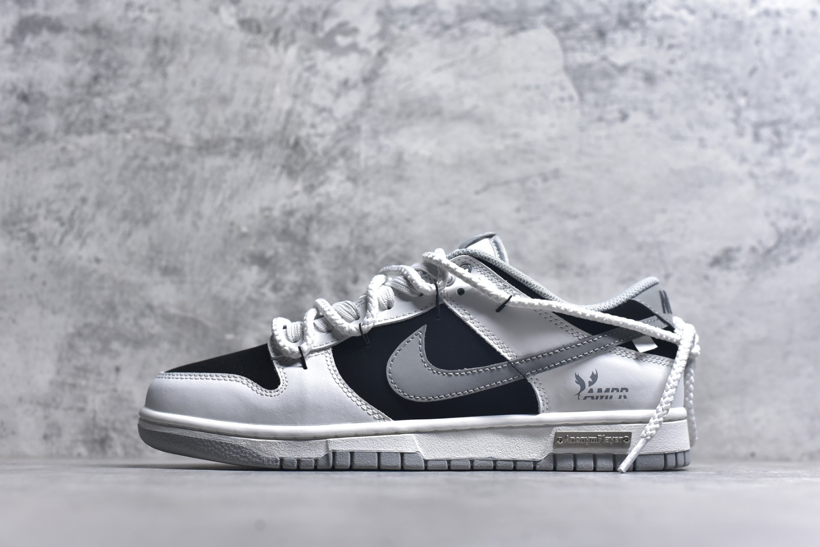 #Nike Dunk Low 墨之影 高端定制 此款以经典Dunk鞋型为模版，上演一场黑白灰的视觉艺术。白色主调极致清爽，易于搭配，深灰色Swoosh以破墨笔法勾勒出凌厉轨迹。侧翼飞翼Logo如印章压角，后跟「AMPR」代号低调烙印身份。黑白灰的层次随光影流动，高级感已在虚实浓淡间自成格局。 货号： WB0518-091 尺码： 40 40.5 41 42 42.5 43 44 44.5 45 46-选品中心
