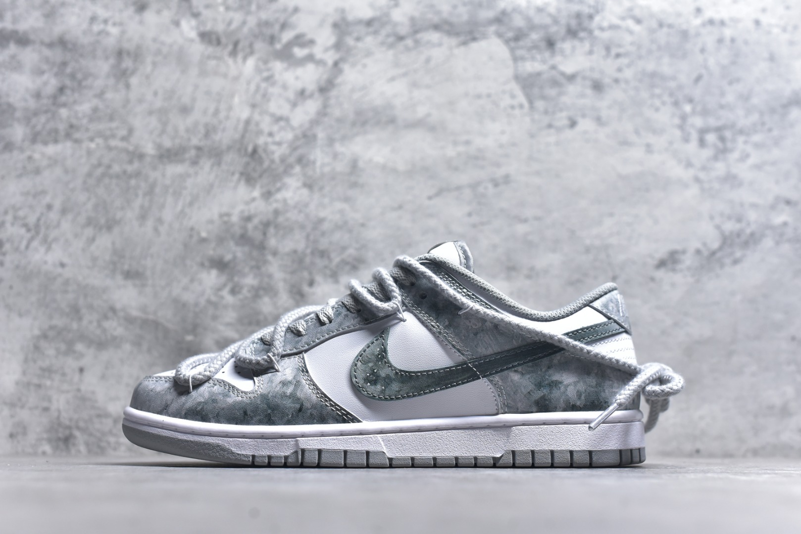 #Nike Dunk Low 凝灰纪元 灰色 鞋身以纯白为画布，如初雪覆盖的旷野，而迷彩般的灰纹肆意蔓延，赋予鞋面立体触感与地质张力。侧身Swoosh以哑光灰低调勾勒，恰如暗藏于纪元深处的符号印记。灰度并非单调，而是层次的艺术：当岩石的肌理落入初雪之境，从浅灰的朦胧到深灰的锐利，以灰度美学重新定义你的穿搭法则。 货号： HF5441-105 尺码： 40 40.5 41 42 42.5 43 44 44.5 45 46-选品中心