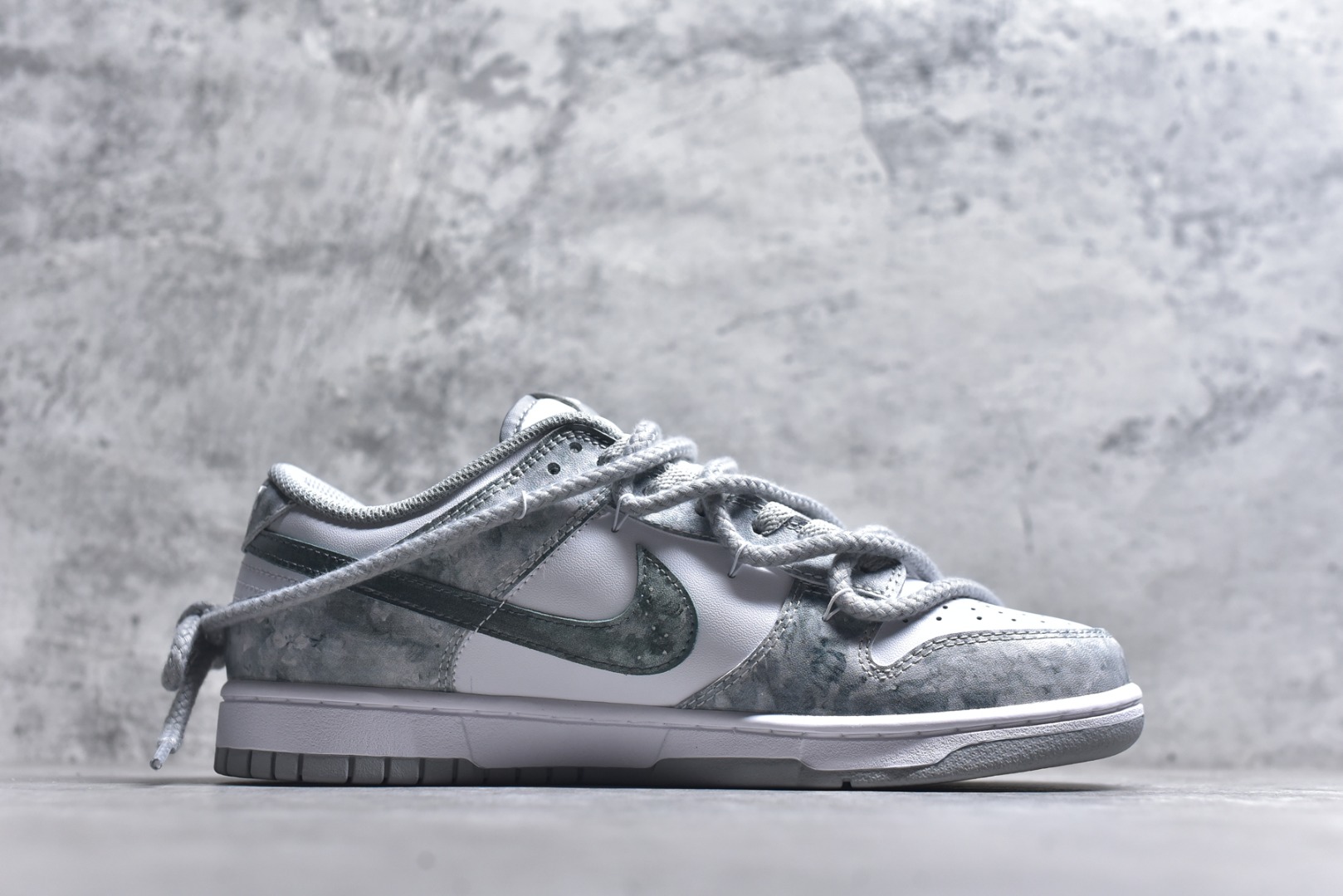 图片[3]-#Nike Dunk Low 凝灰纪元 灰色 鞋身以纯白为画布，如初雪覆盖的旷野，而迷彩般的灰纹肆意蔓延，赋予鞋面立体触感与地质张力。侧身Swoosh以哑光灰低调勾勒，恰如暗藏于纪元深处的符号印记。灰度并非单调，而是层次的艺术：当岩石的肌理落入初雪之境，从浅灰的朦胧到深灰的锐利，以灰度美学重新定义你的穿搭法则。 货号： HF5441-105 尺码： 40 40.5 41 42 42.5 43 44 44.5 45 46-选品中心