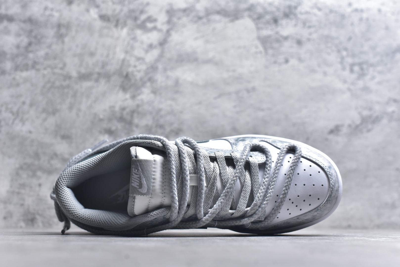 图片[4]-#Nike Dunk Low 凝灰纪元 灰色 鞋身以纯白为画布，如初雪覆盖的旷野，而迷彩般的灰纹肆意蔓延，赋予鞋面立体触感与地质张力。侧身Swoosh以哑光灰低调勾勒，恰如暗藏于纪元深处的符号印记。灰度并非单调，而是层次的艺术：当岩石的肌理落入初雪之境，从浅灰的朦胧到深灰的锐利，以灰度美学重新定义你的穿搭法则。 货号： HF5441-105 尺码： 40 40.5 41 42 42.5 43 44 44.5 45 46-选品中心