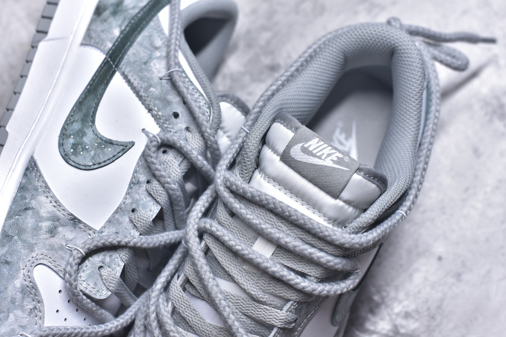 图片[9]-#Nike Dunk Low 凝灰纪元 灰色 鞋身以纯白为画布，如初雪覆盖的旷野，而迷彩般的灰纹肆意蔓延，赋予鞋面立体触感与地质张力。侧身Swoosh以哑光灰低调勾勒，恰如暗藏于纪元深处的符号印记。灰度并非单调，而是层次的艺术：当岩石的肌理落入初雪之境，从浅灰的朦胧到深灰的锐利，以灰度美学重新定义你的穿搭法则。 货号： HF5441-105 尺码： 40 40.5 41 42 42.5 43 44 44.5 45 46-选品中心